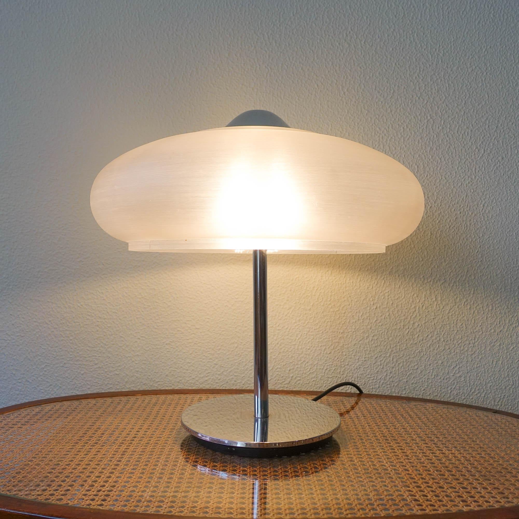 This table lamp was designed and produced in Germany, during the 1970's.The base is made of chrome metal where an plastic mushroom shaped shade is set. It is in the original and good condition.