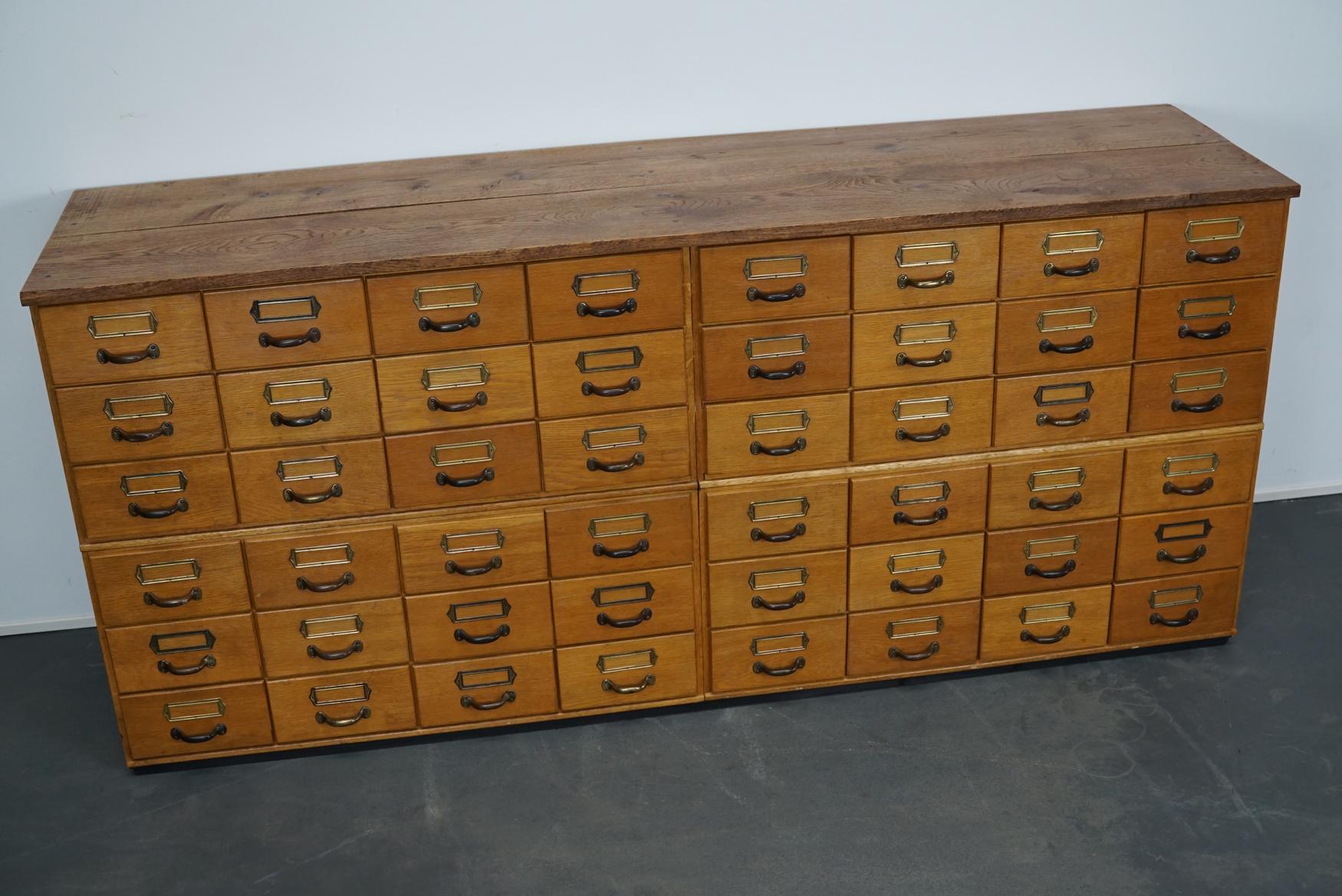 This apothecary cabinet was produced during the 1950s in Germany. This piece features 48 drawers with nice brass card holders and pulls. The interior dimensions of the drawers are: D x W x H 40 x 19 x 4.5 / 9 cm.
