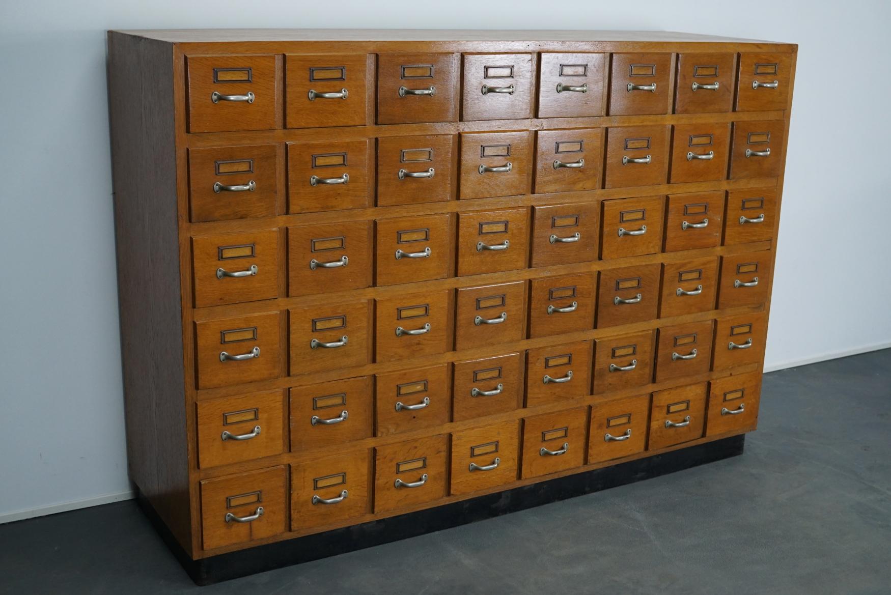 This apothecary cabinet was produced during the 1950s in Germany. This piece features 48 drawers with nice card holders and pulls. The interior dimensions of the drawers are: D x W x H 34 x 15.5 x 13 cm. The cabinet was used in a pharmacy in west