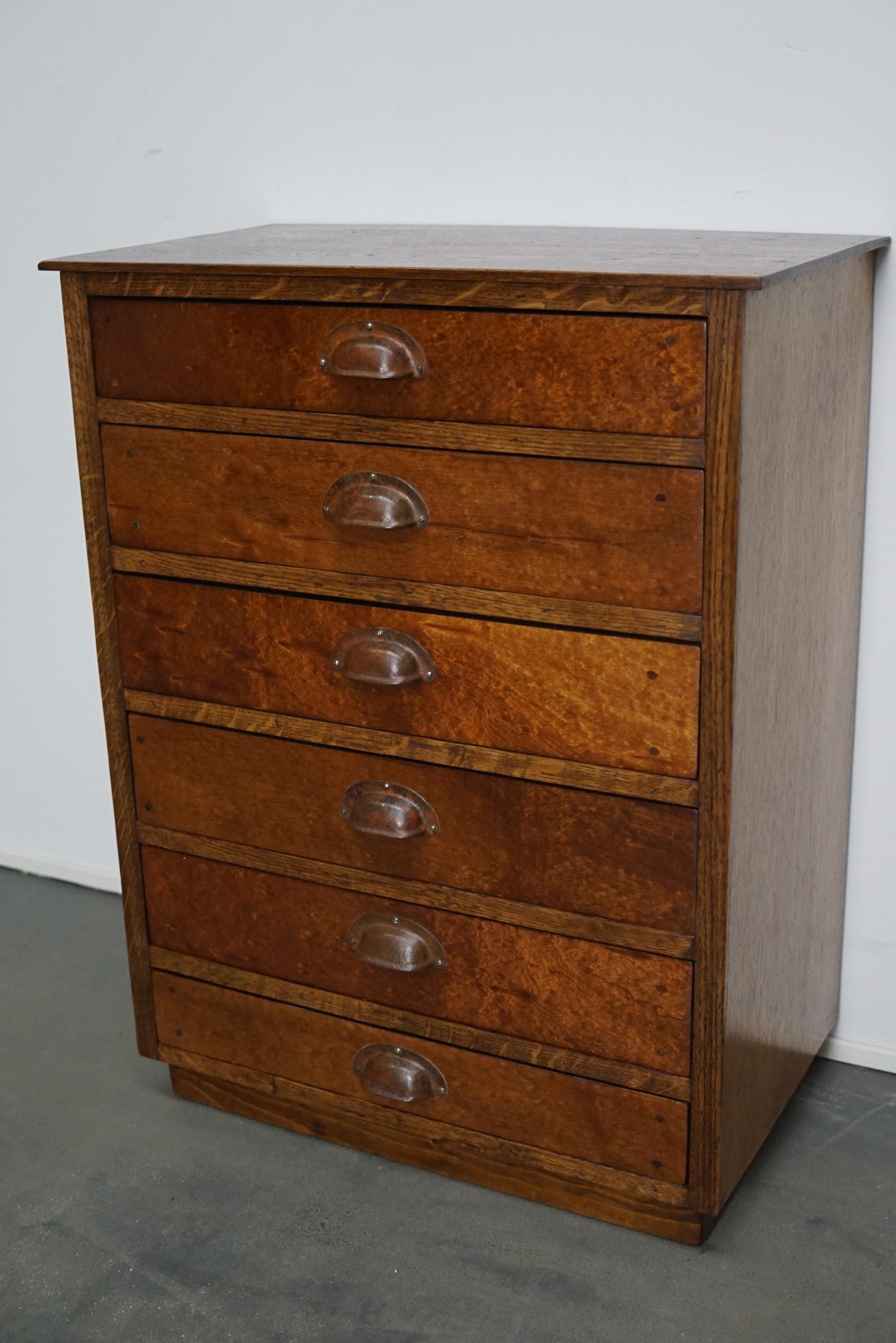 Questo armadietto da farmacia è stato realizzato intorno agli anni '50 in Germania. Dispone di 6 cassetti con maniglie a tazza in metallo. La struttura e il piano del mobile sono in Oak, mentre i frontali dei cassetti sono impiallacciati in mogano.