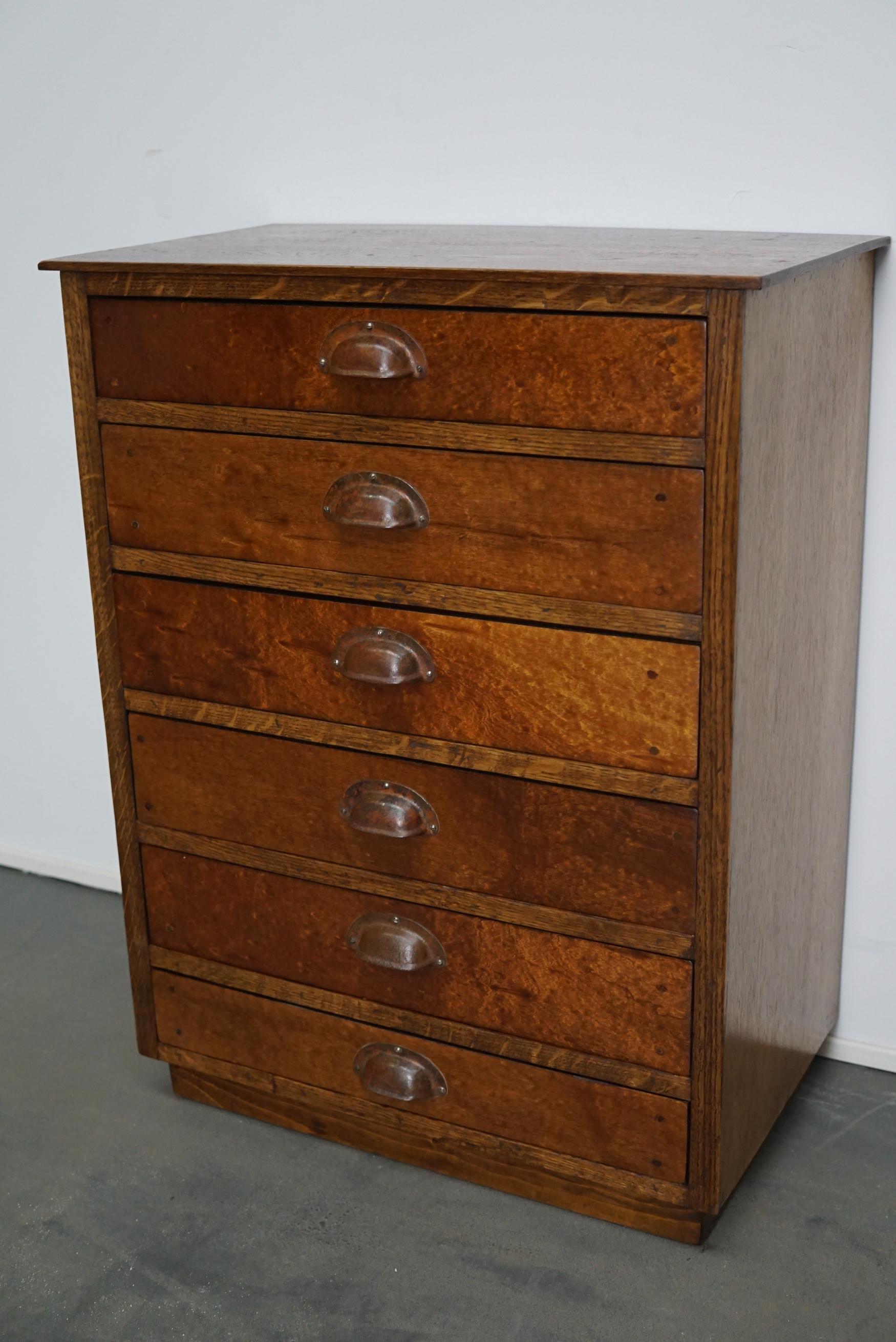 This apothecary cabinet was made circa 1950s in Germany. It features 6 drawers with metal cup handles. The frame and top of the cabinet are made of oak, the fronts of the drawers are mahogany veneer. It remains in a good restored condition. The