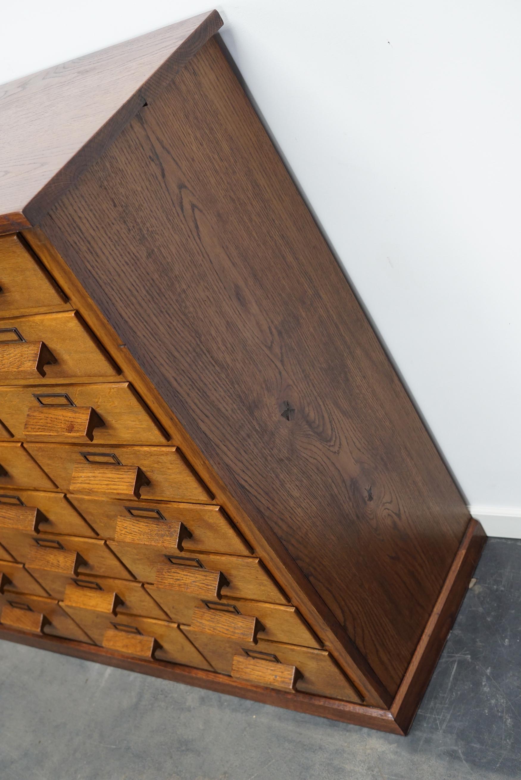 Dieser Apothekerschrank wurde um 1940 / 1950 in Deutschland aus Eiche gefertigt. Er verfügt über 32 Schubladen mit schönen Holzgriffen und Namenskartenhaltern. Die Innenmaße der Schubladen sind: DWH 35 x 27 x 7,5 cm.