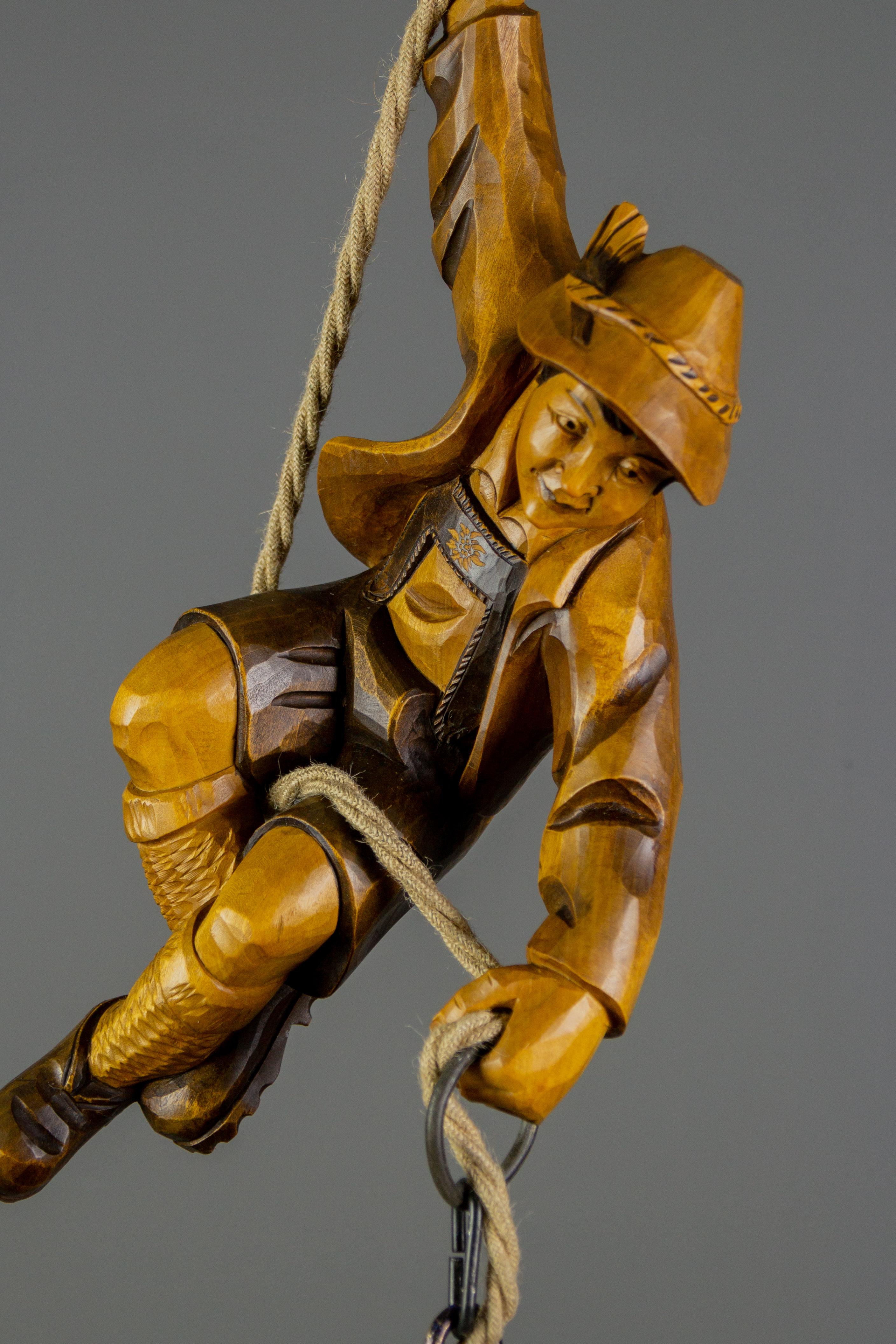 Wonderful German figural pendant lamp features a hand-carved figure of a mountain climber. The detailed carved wooden mountaineer is holding onto a rope and holding a lantern in one hand. The figure is in beautiful brown colors.
The height of the