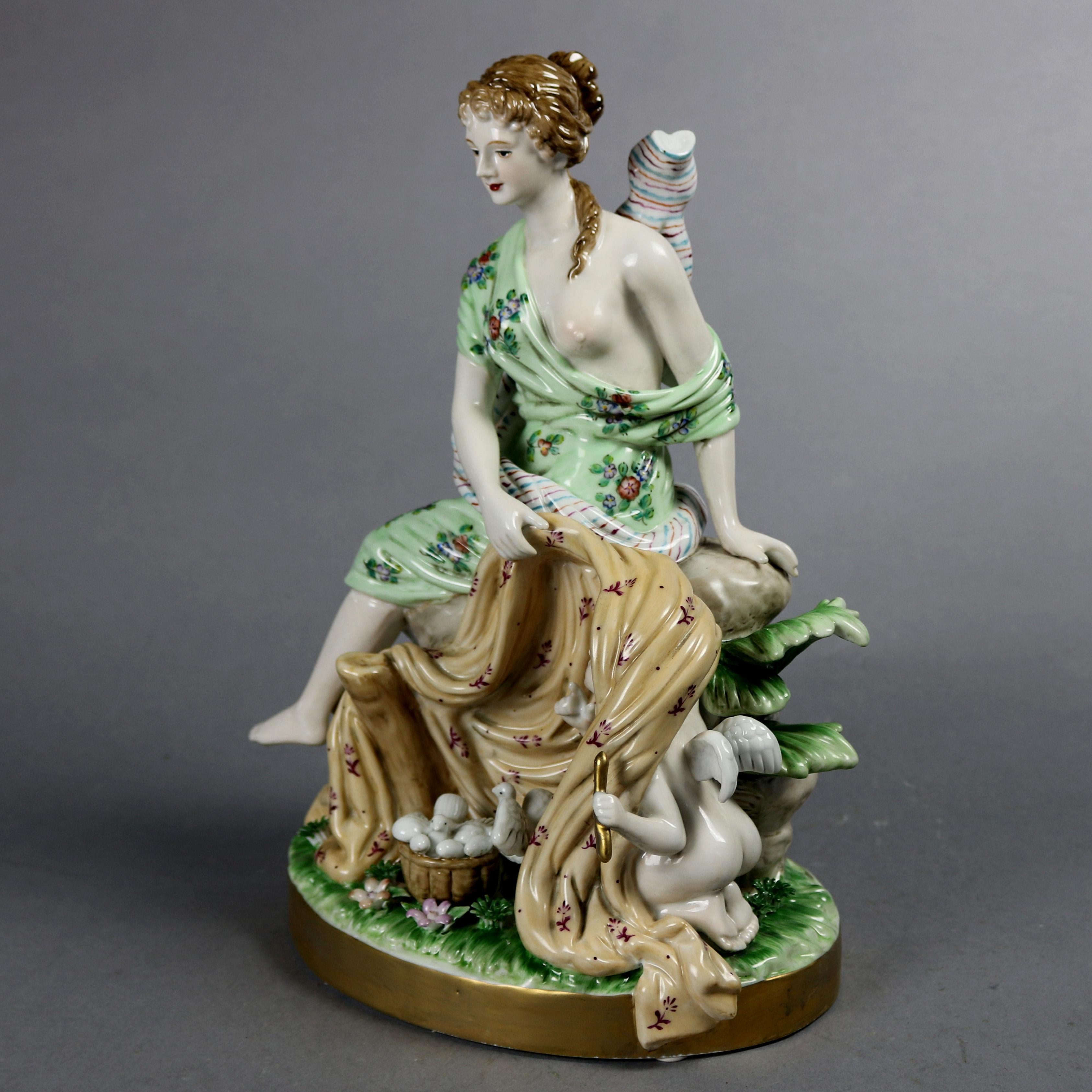 A German porcelain grouping offers hand painted and gilt partial nude Classical woman with playful cherub hiding beneath a blanket in countryside setting, RK Dresden Germany mark on base as photographed, 20th century

Measures: 12.75