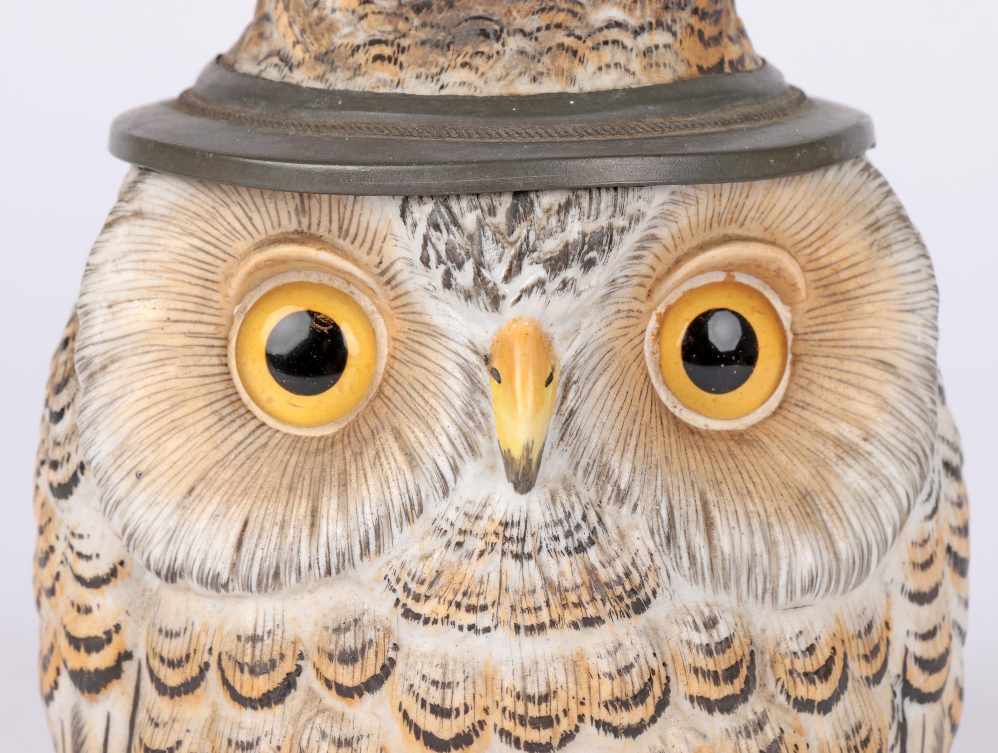 An exceptional antique German attributed porcelain beer stein modelled as an owl and dating from the latter 19th century. The stein is of rounded bulbous shape with a large twig styled handle with oak leaf terminals and with a pewter mounted hinged