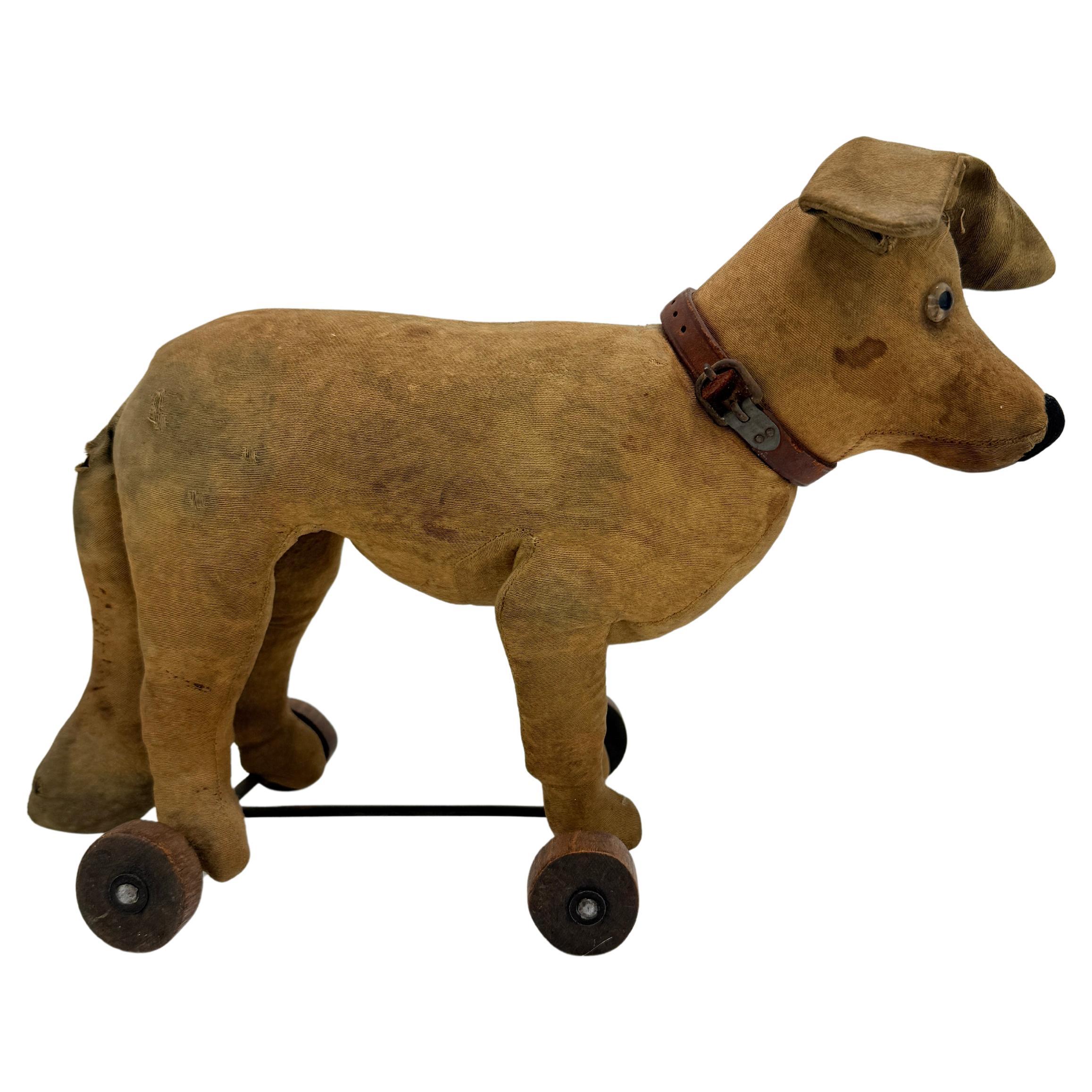 A rare and finely constructed early 20th-century German pull toy dog, attributed to the Steiff company or a Thuringian workshop operating in the Steiff tradition, circa 1900–1915. The figure is rendered in light tan twill fabric over a softly