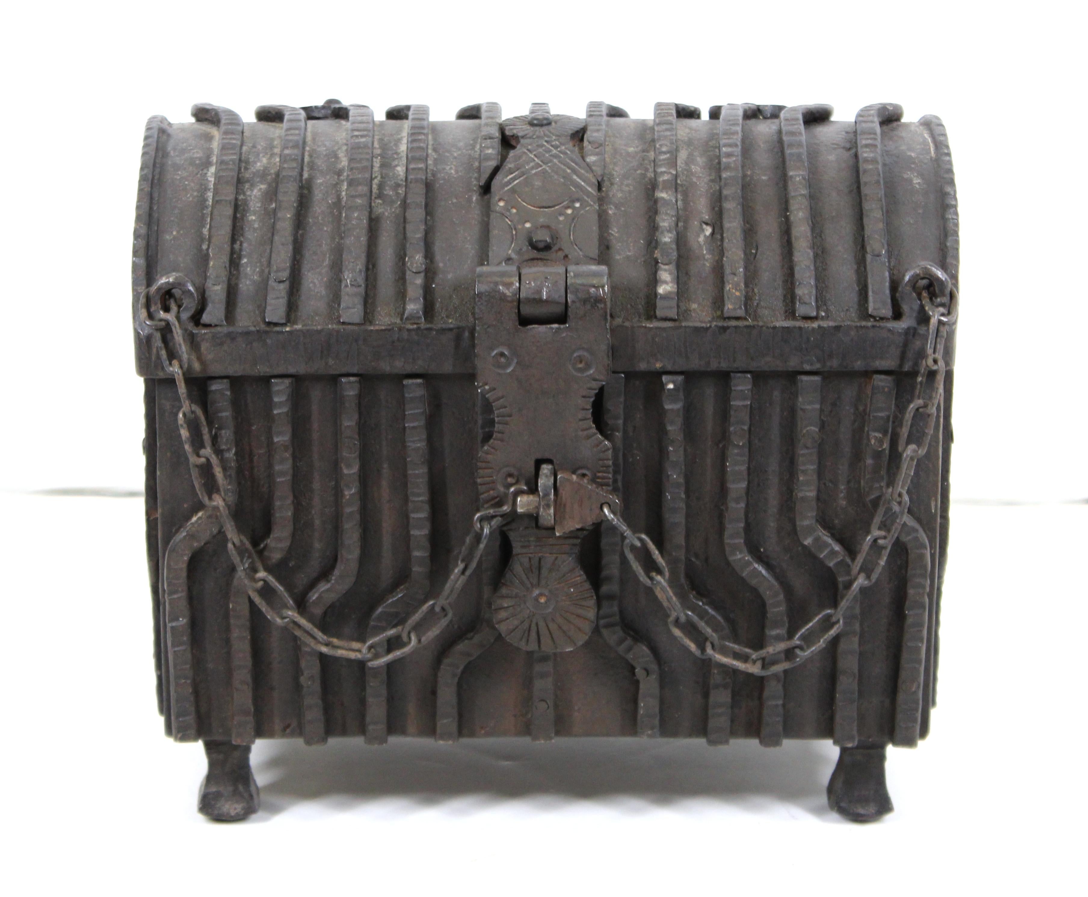 German Renaissance Revival period heavy wrought iron strong box with lock and chain closure. The piece is in a shape reminiscent of a treasure chest and has a red velvet interior. Made in Germany in the 1900s and is in great antique condition with