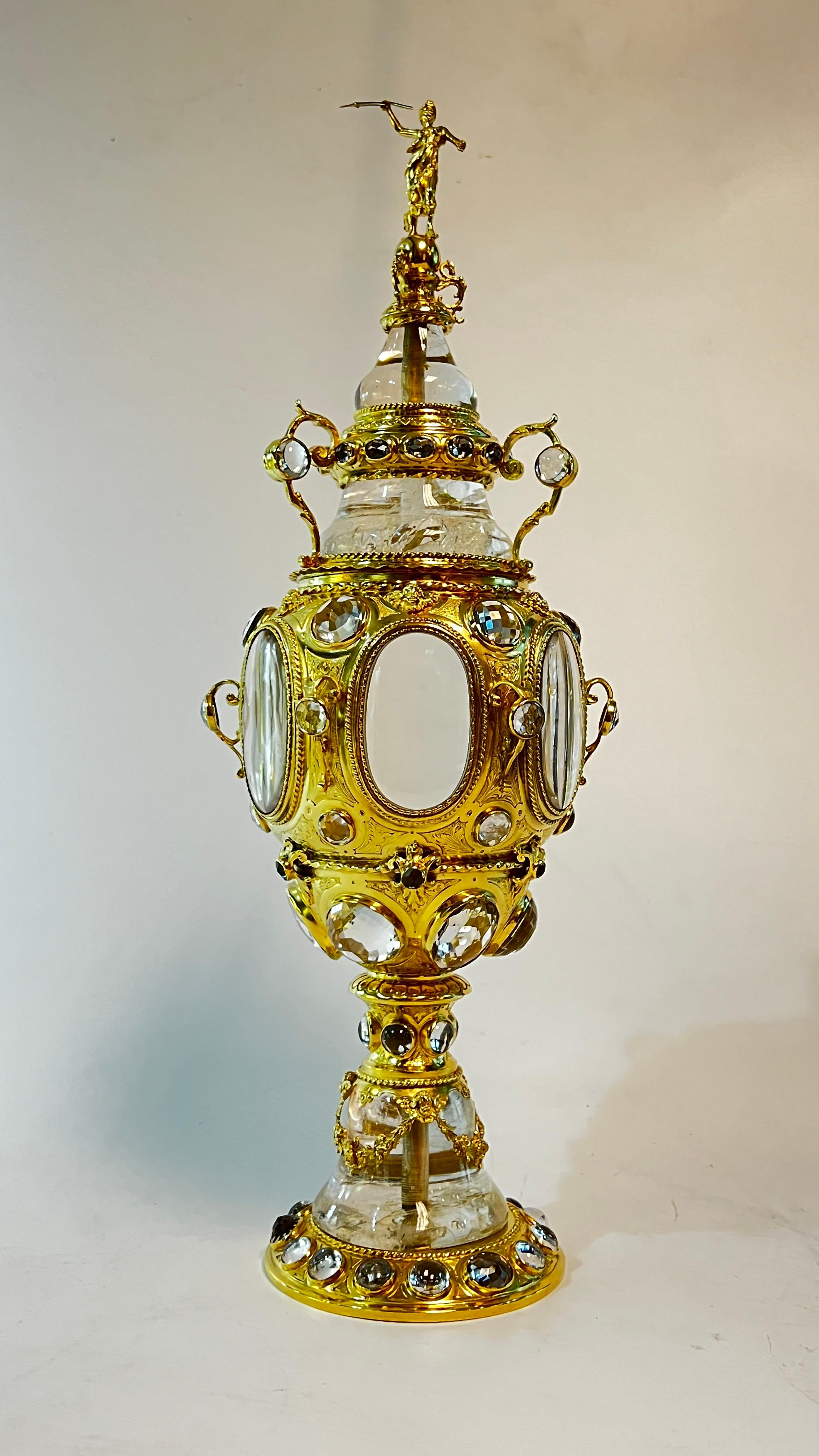 Our extraordinary German cup and cover in the Baroque style, circa 1880s, is crafted from gilt brass and features extensive use of rock crystal, including cabochon and faceted circular jewels. Apparently unsigned. Provenance: Koopman Rare Art,