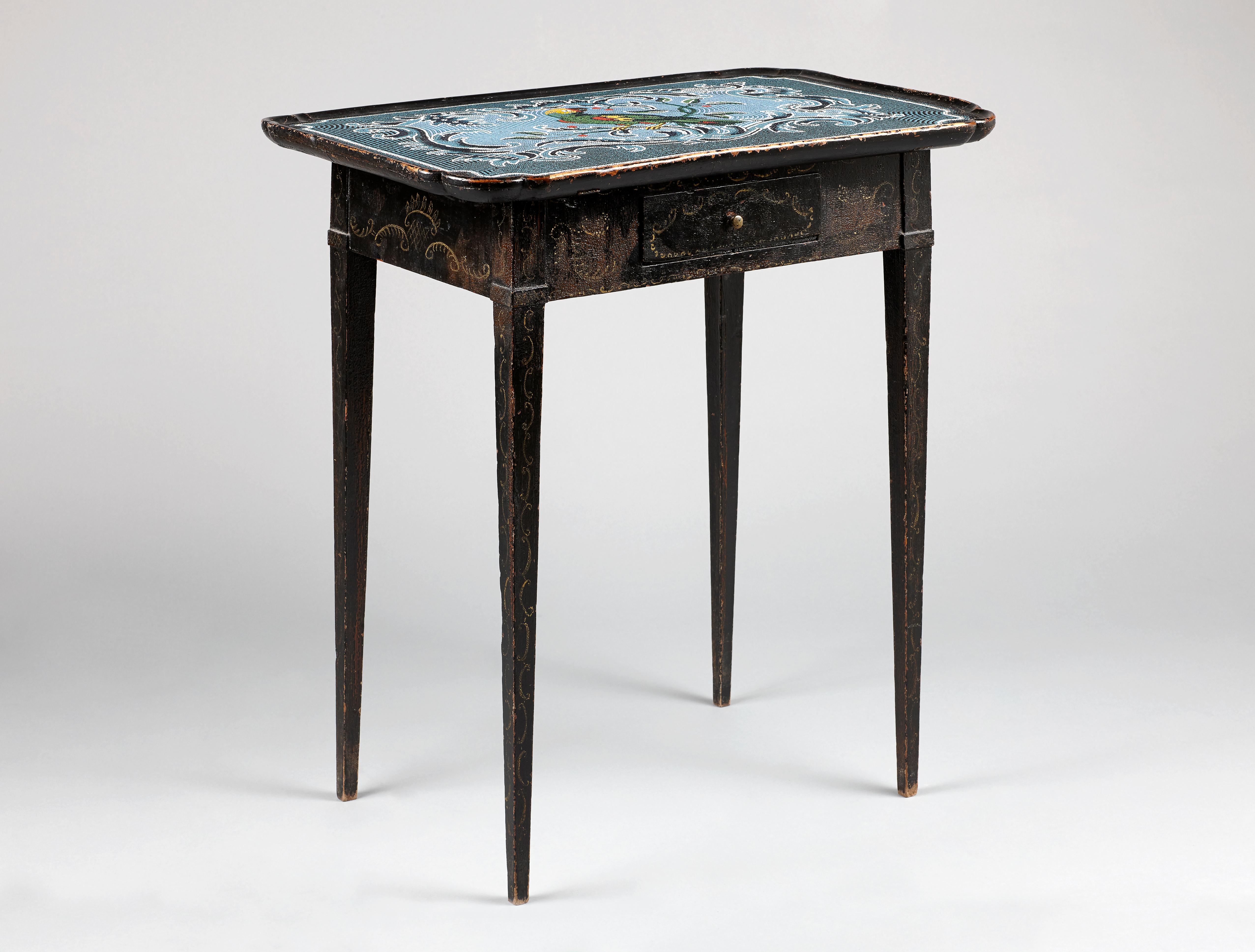 A very rare 18th century German Rococo table. Oak and pinewood with historical paint in black and decoration in gold color. The rounded rectangular dished top with moulded edge and decorated with a mosaic made of glass beads depicting a parrot