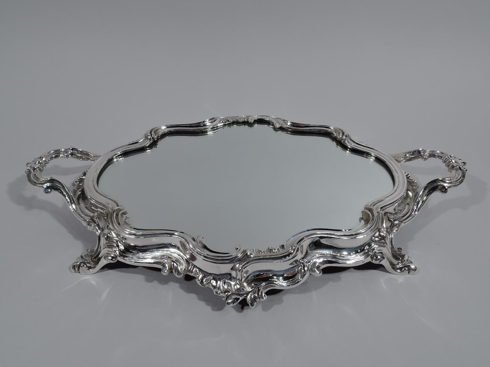 German Rococo Revival 900 silver plateau, circa 1950. Shaped oval with fluid scrolls flowing into four supports. Two scrolled-bracket end handles. Well inset with mirror. Underside velvet lined. Fully marked.

Overall dimensions: H 2 1/4 x W 19 x
