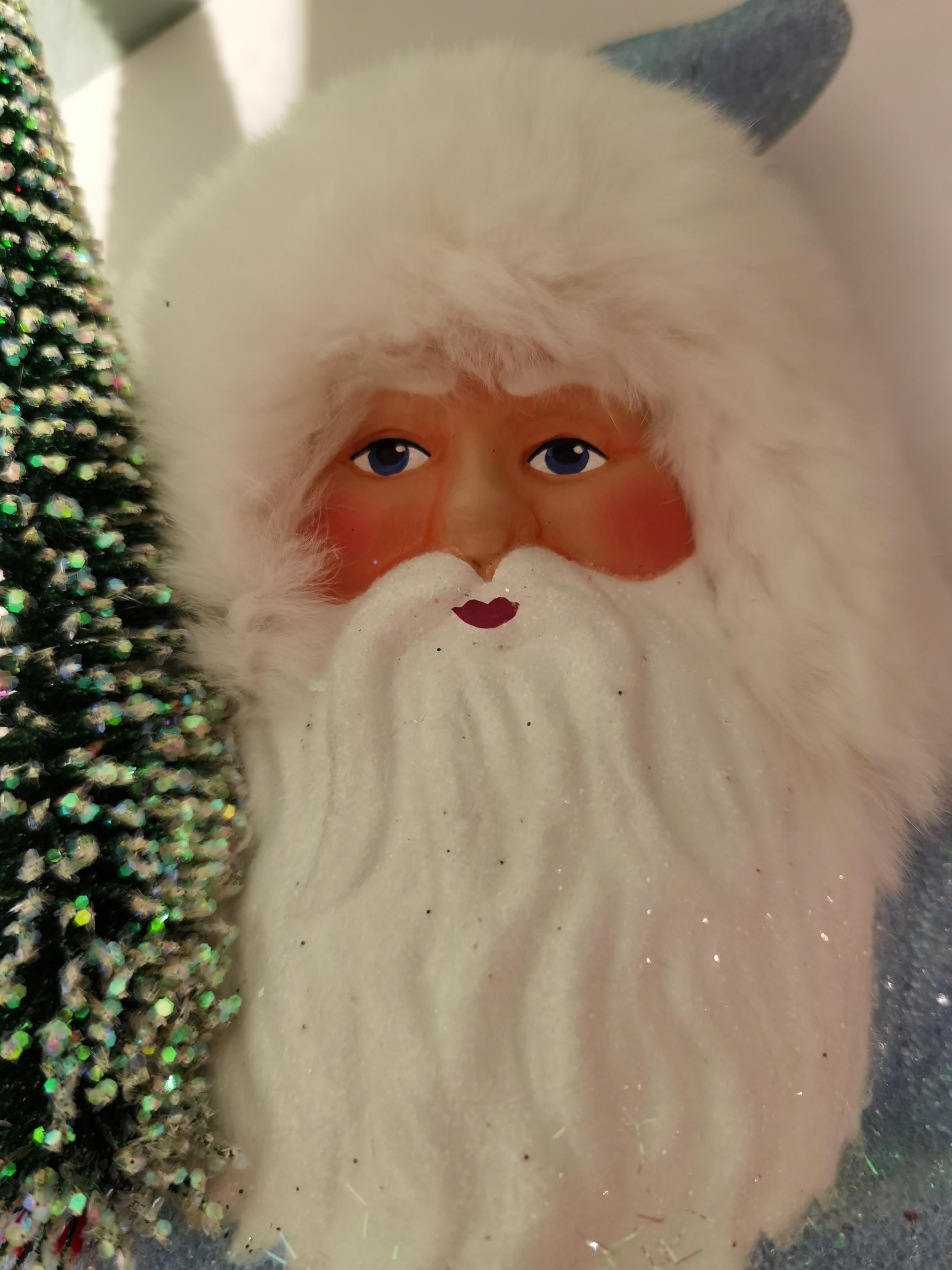Large Santa Claus figure in papier mâché blue with a hand painted detailed face holding a tree. Real white fur. The Santa Claus is handmade in a original mould in Germany.