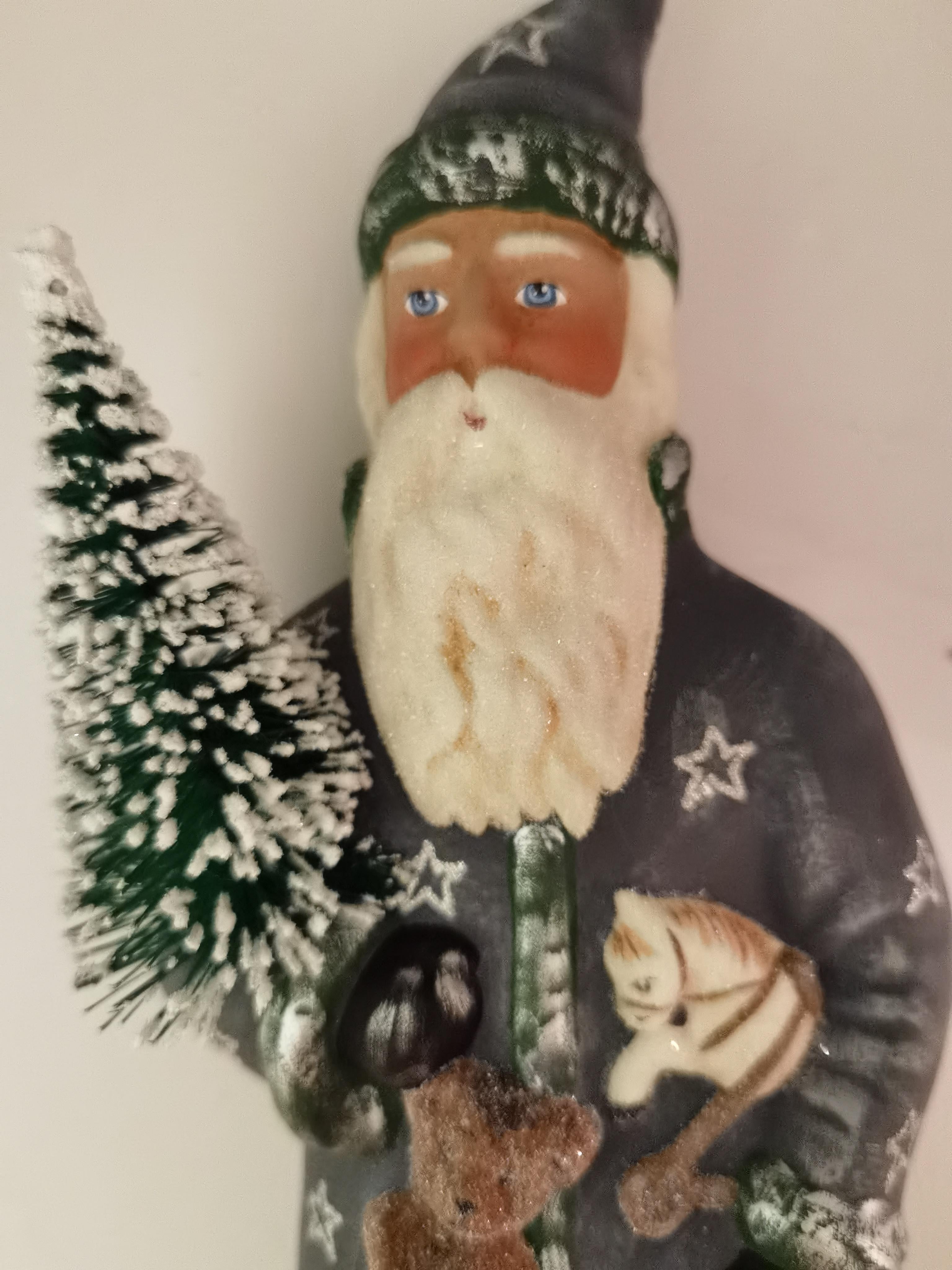 Santa Claus figure in hand painted gold papier mâché decorated with stars and a hand painted detailed face holding a tree. The Santa Claus is handmade in a original antique mould in Germany.