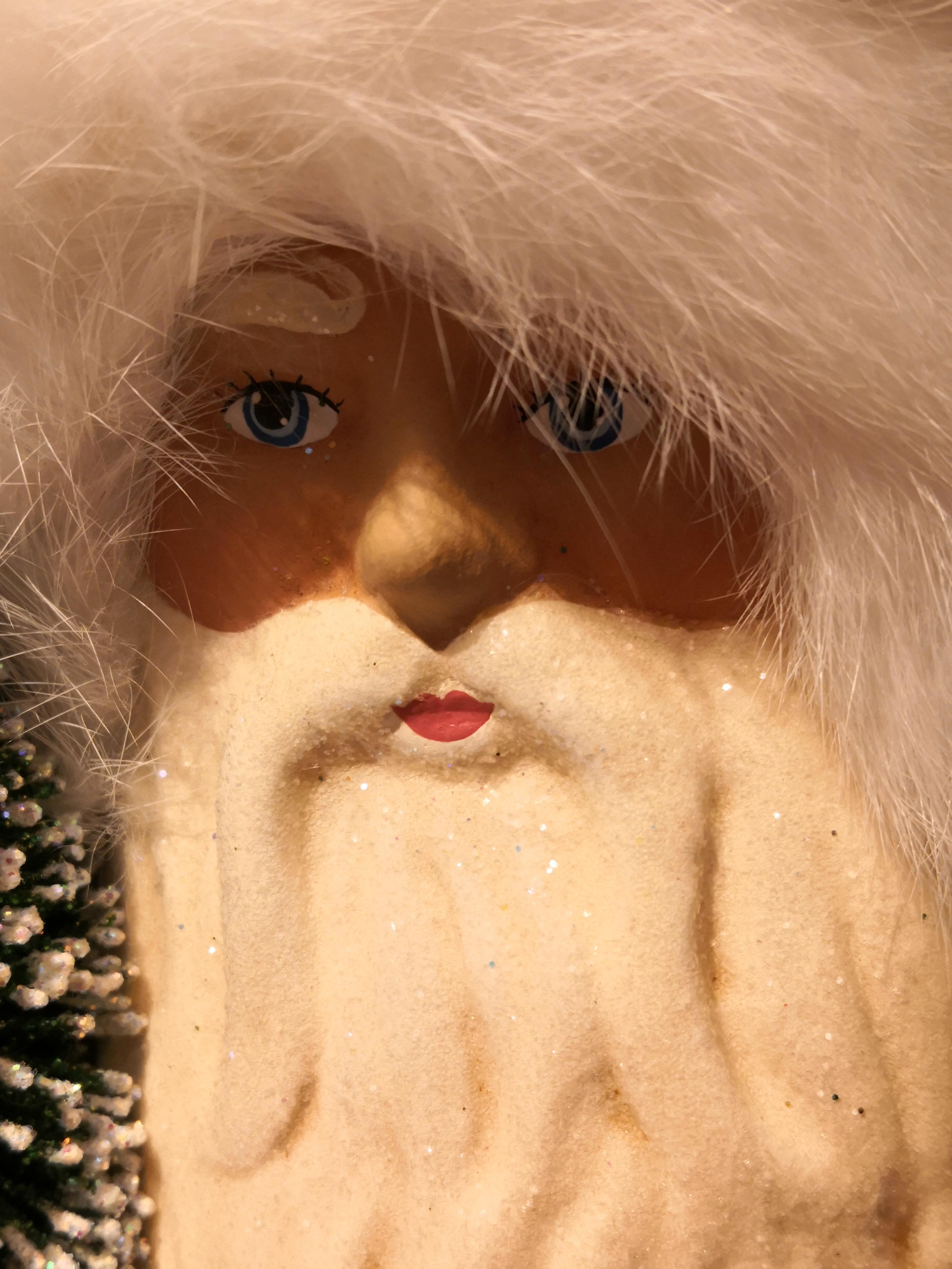 Large Santa Claus figure made in papier mâché with a hand painted detailed face. Holding a tree and decorated with glitter details and a real fur rim.
The Santa Claus is handmade in the original antique mold in Germany. Comes in different colors.