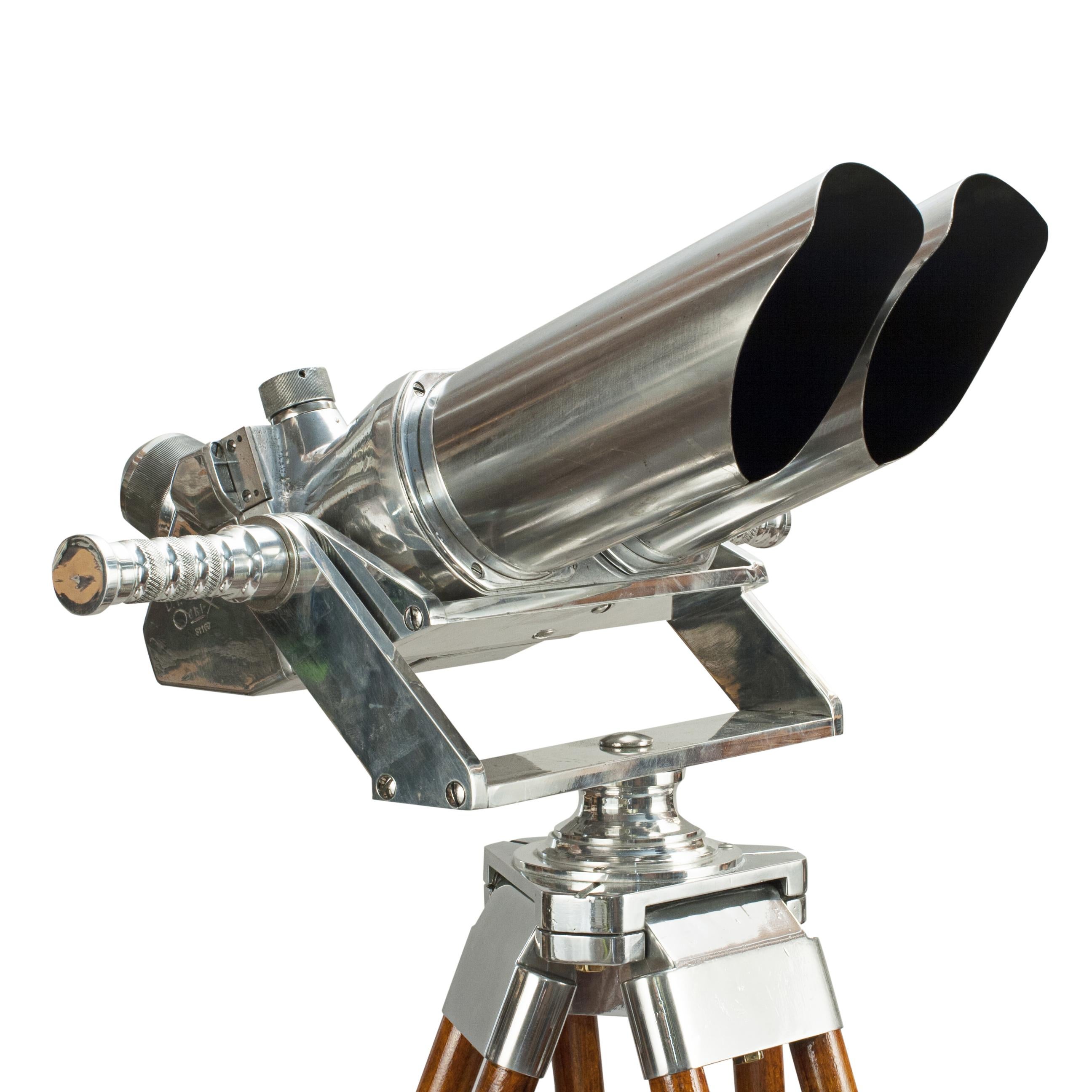 German Schneider Observation Binoculars, 10 X 80.

A pair of German ex-military observation binoculars mounted on a modern aluminium cradle and gimble with vintage adjustable wooden tripod. The binoculars with 45º incline eyepieces and are marked