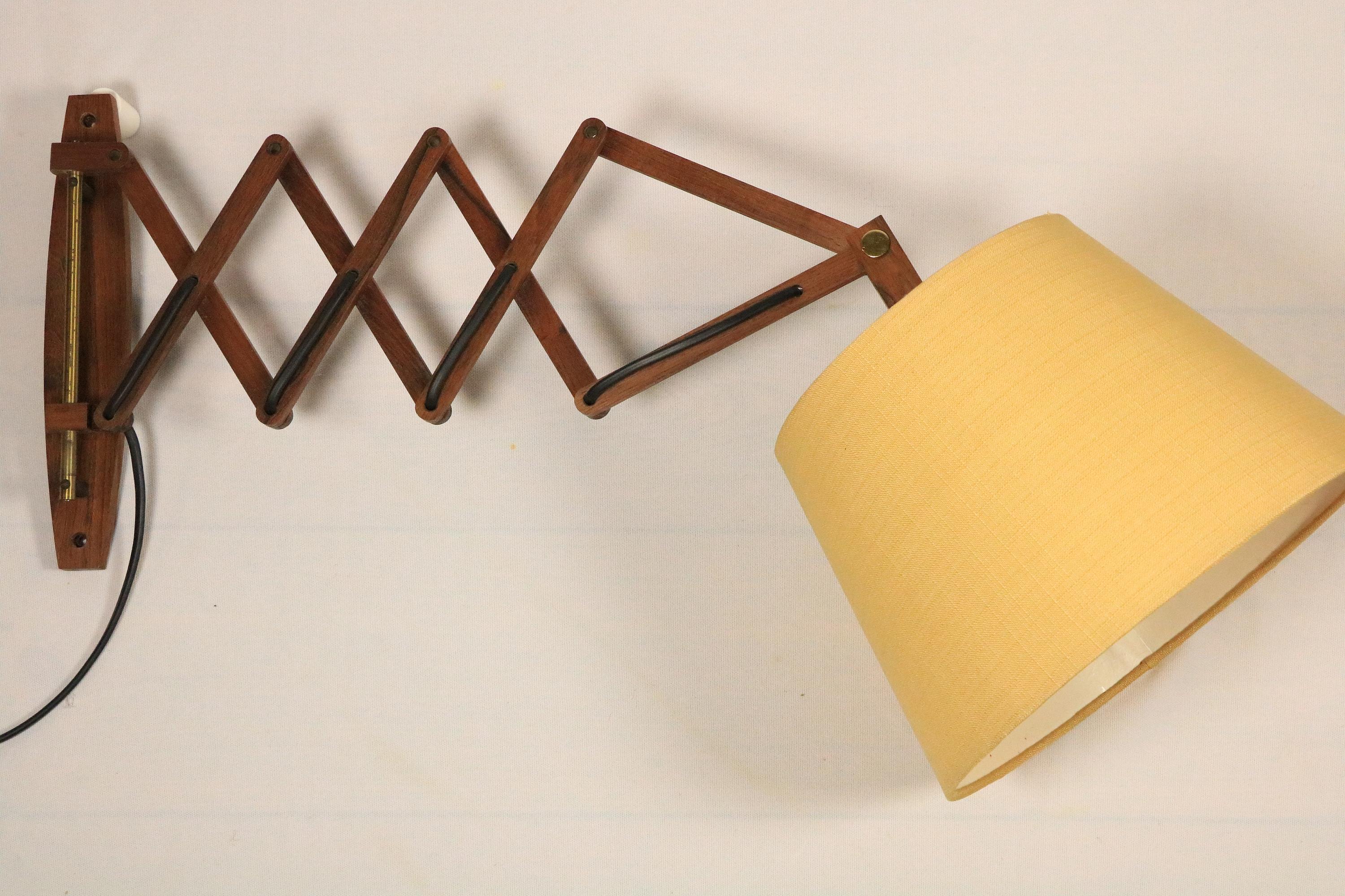 Beautiful and very practical classic from the 1970s.

Wooden scissor wall lamp. Adjustable.
With a textile shade in a warm yellow beige colour.

Diameter of the shade: 27 cm / 10.63 inches

In good condition with slight signs of wear.