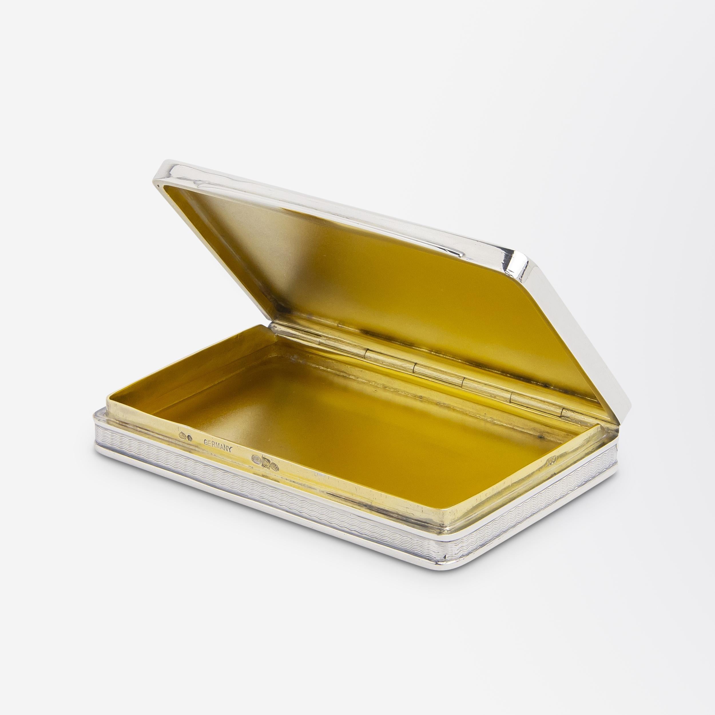 Les émaux d'un bleu profond qui ornent le recto et le verso de cette tabatière de fabrication allemande donnent l'impression de petites piscines dans lesquelles on a envie de plonger. Fabriquée en argent d'une pureté de 900 (900/1000 parties