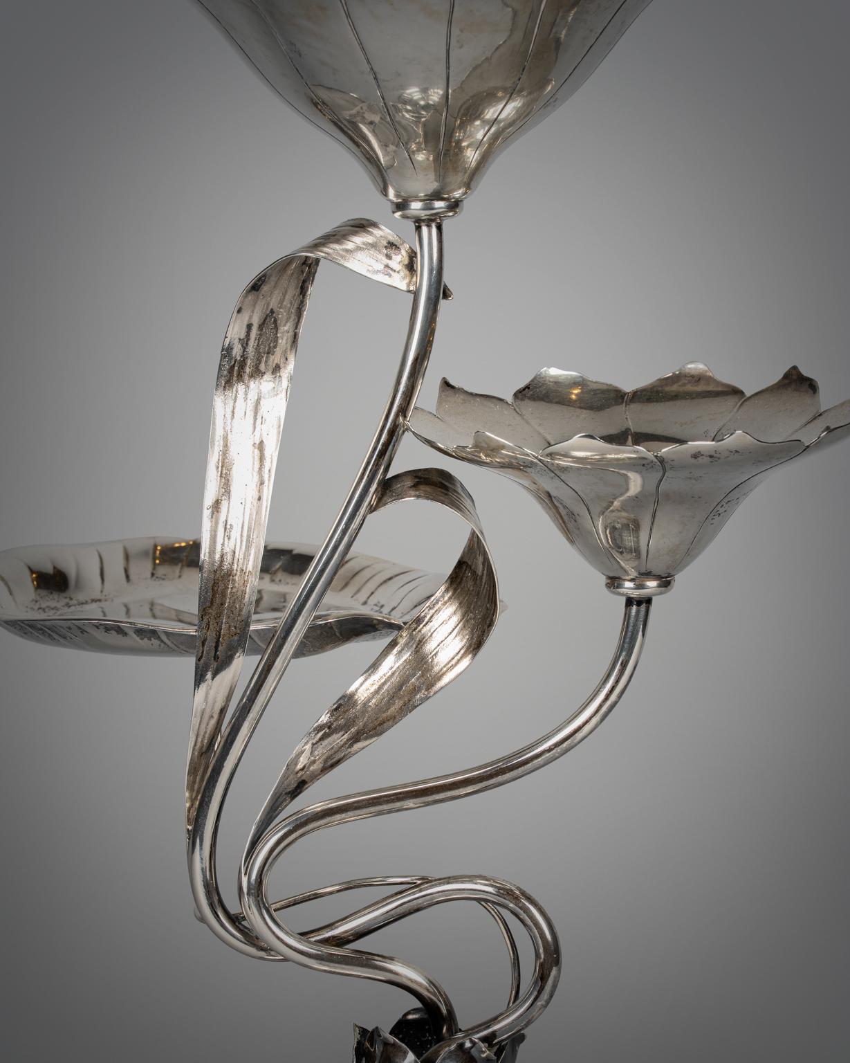 Les tiges incurvées émanent du centre d'une base à gradins de forme florale, se terminant par deux fleurs ouvertes et un pad en forme de feuille de lotus. Marqué en dessous. 