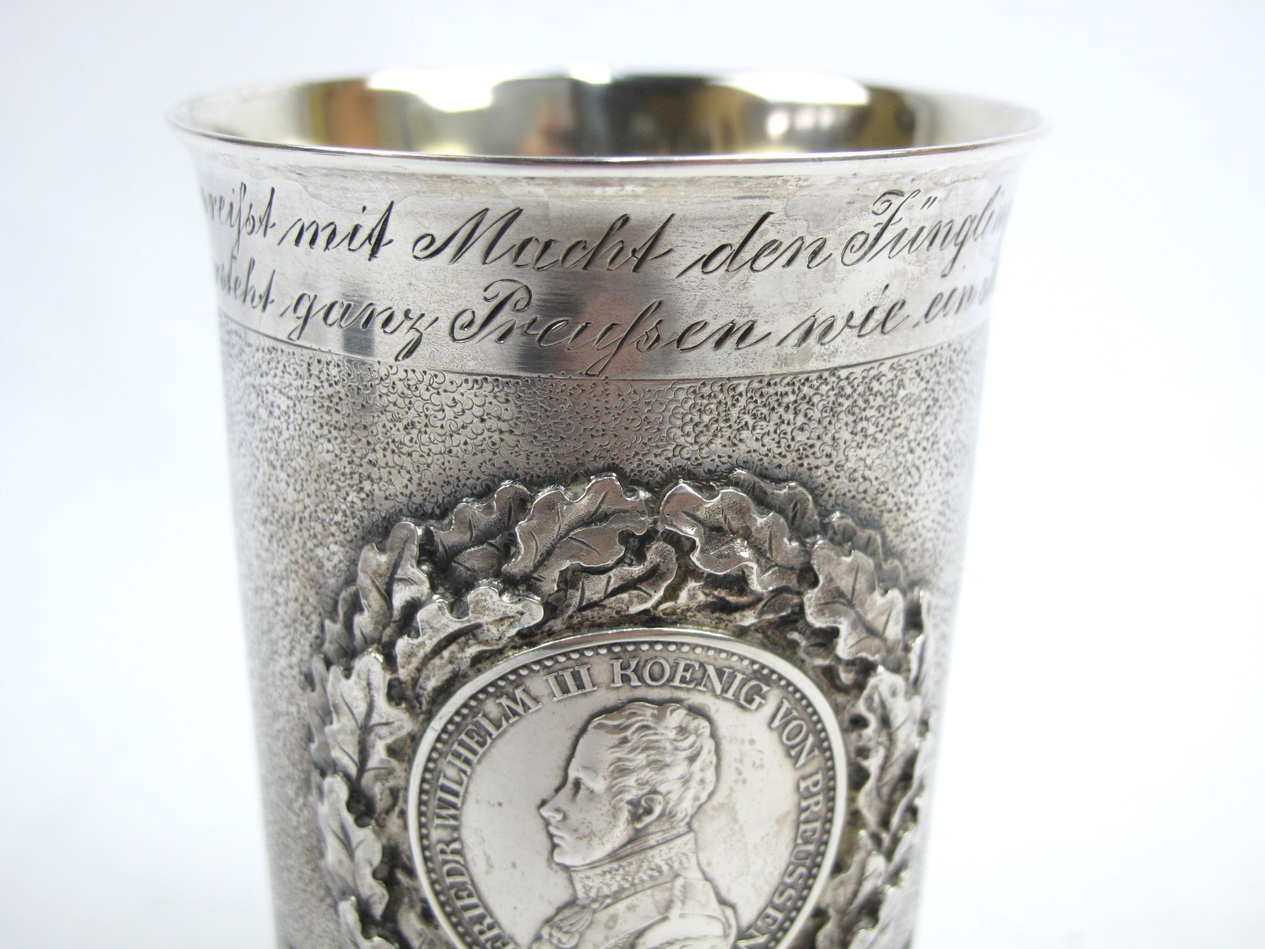 German Silver commemorative beaker belonging to a named veteran of the Garde-Volontar-Kosak. An interesting variant of the Munzbecher (coin beaker) style drinking cup or pokal. 

The Garde-Volontar-Kosak was a squadron of volunteers (exempt from