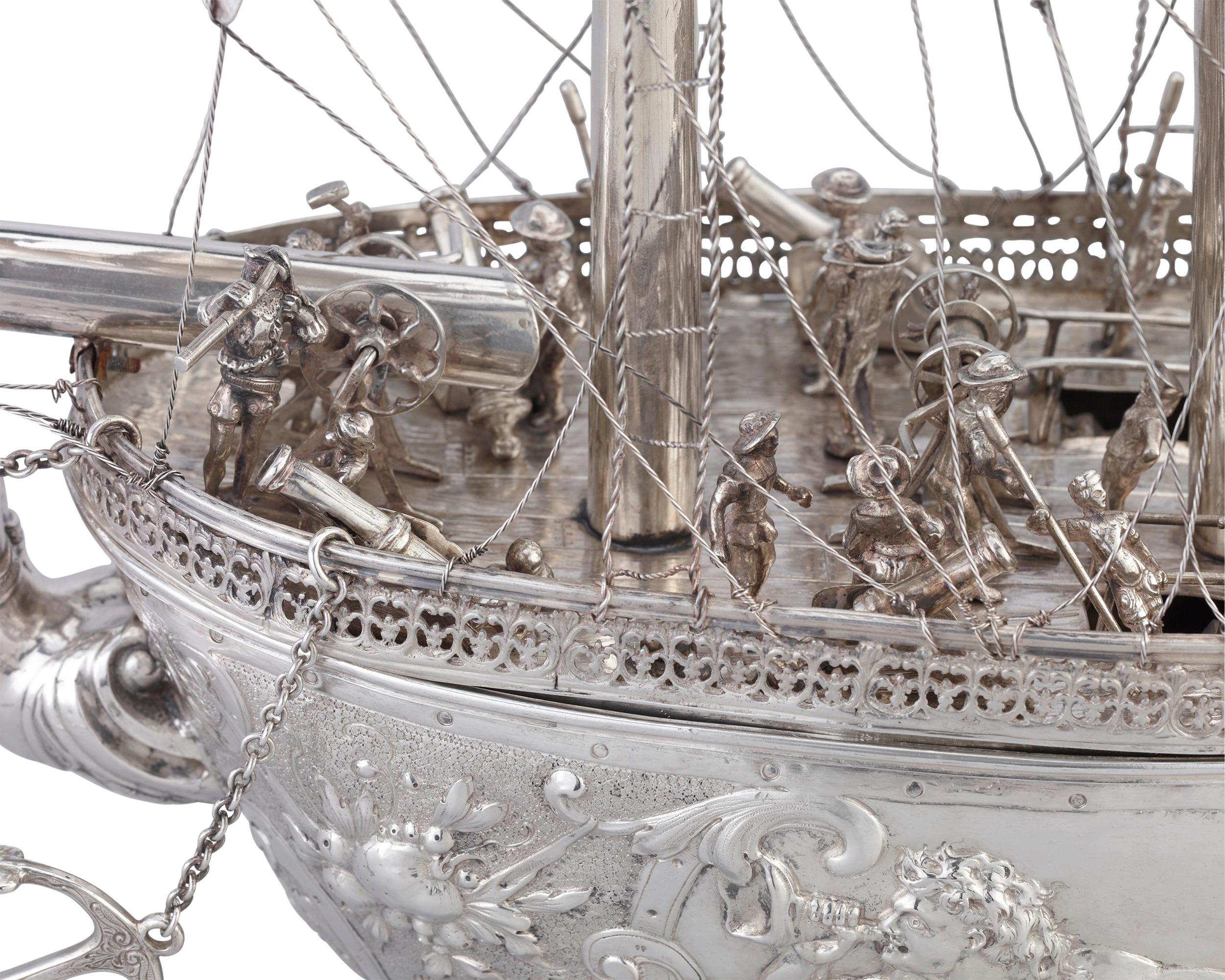 Measuring nearly three feet in length, this monumental silver nef is a spectacular example of German silverwork from the town of Hanau. It is masterfully crafted, with three masts and a deck fully manned and rigged with sailor figures. Mermen, putti