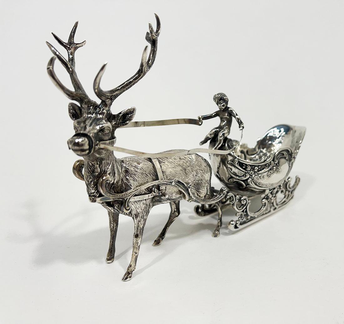 Renna tedesca in argento con slitta di Schleissner & Söhne

Centrotavola in argento con renna e slitta in stile rococò, con un cherubino come cocchiere e una renna davanti alla slitta. Questo centrotavola è composto da pezzi separati: la slitta, le