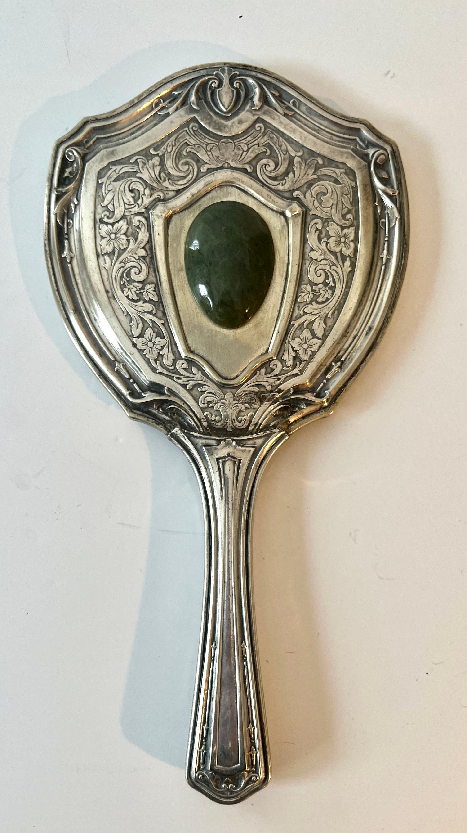 Specchio a mano in argento tedesco con manico e cornice in repousse con dettagli in giada.

Un complemento per ogni bagno, tavolo da toeletta, vanity o armadio personale.

Un delizioso pezzo dell'epoca vittoriana o art déco, all'inizio del XX