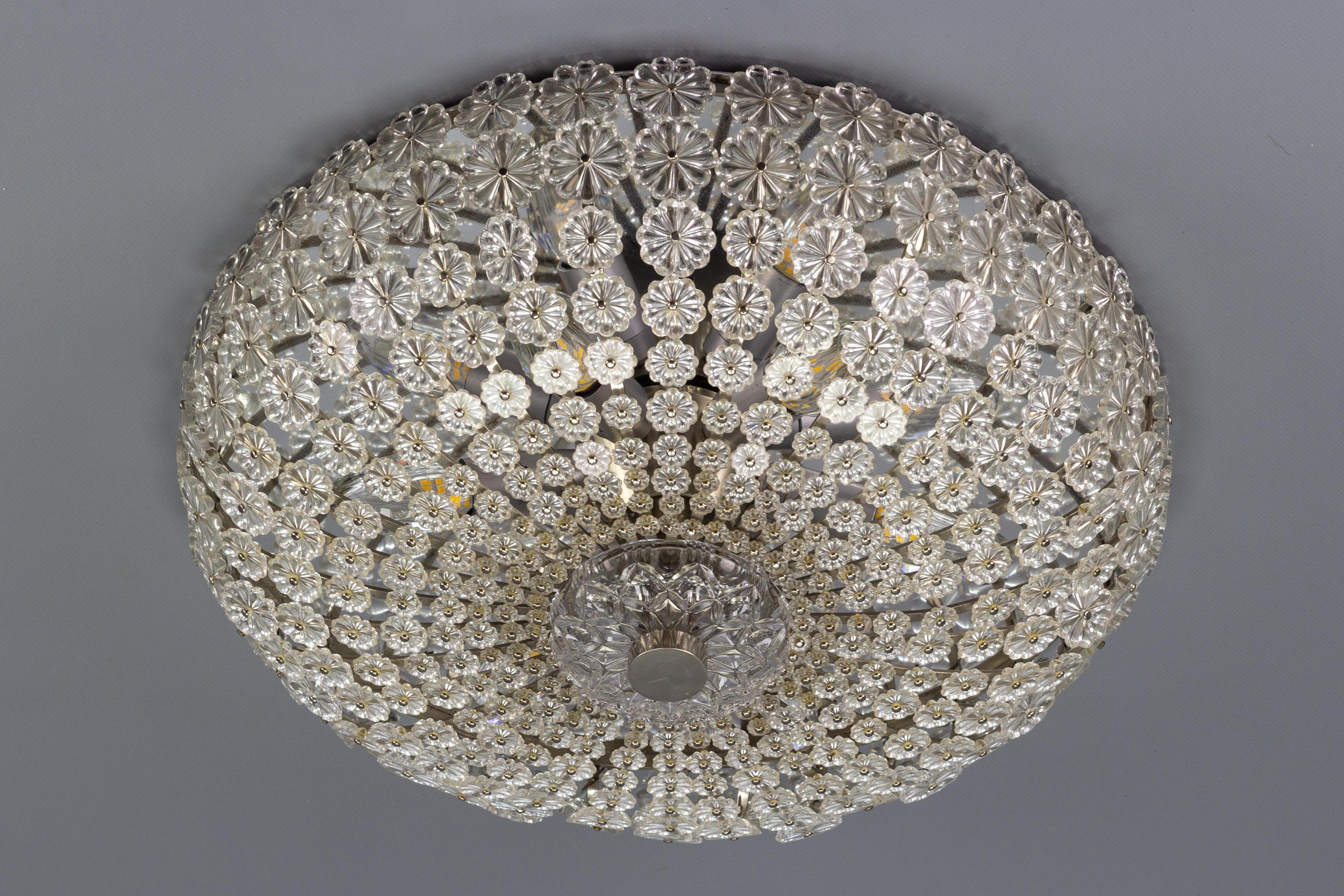 This impressive Space Age or Stejnar period flush mount by H. Richter features a chrome sheet and frame, covered in glass flowers richly decorated from smaller to slightly larger. The beautiful ceiling light fixture is centered with glass and chrome