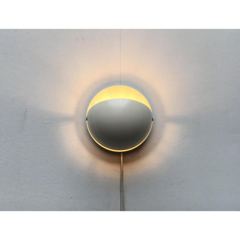 Rare lampe murale de l'ère spatiale par Cosack.

La forme de base de ce design est un hémisphère. Au centre de la source lumineuse, qui est protégée par un capot mobile, se trouve un siège. L'écran en forme de dôme est monté sur deux articulations