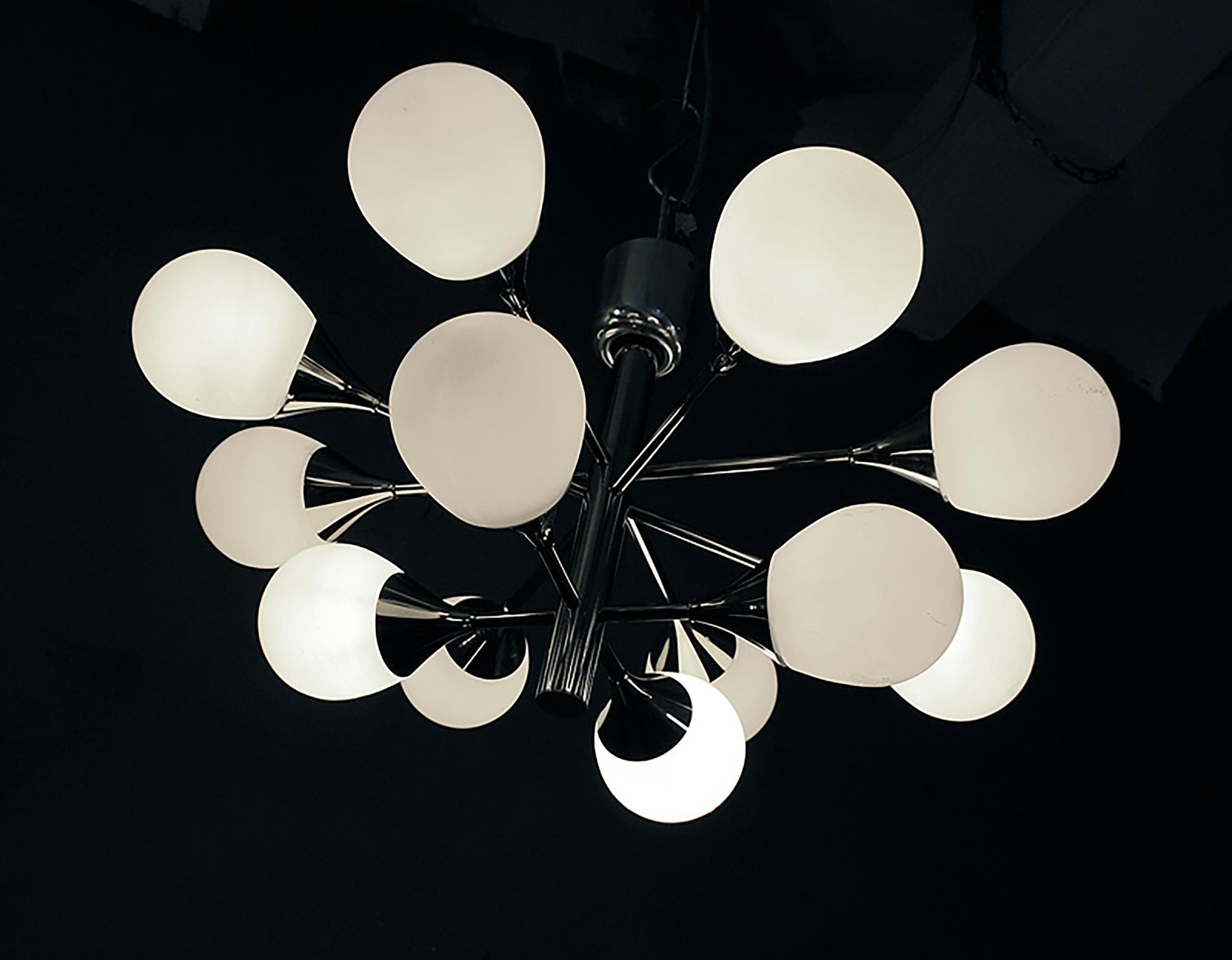 Elegante lampadario da incasso a struttura atomica Sputnik con dodici sfere di vetro bianco su una struttura in metallo cromato. Il lampadario si illumina magnificamente e offre una grande quantità di luce. Prodotto da Kaiser, Germania, negli anni