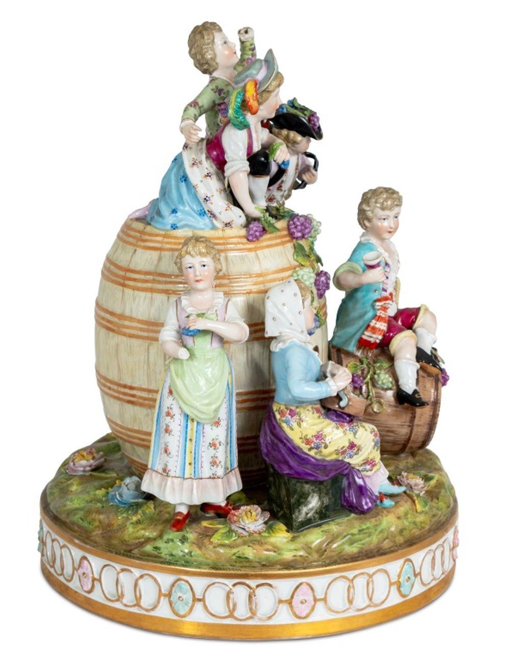 German Thieme Porcelain Figural Group, late 19th century, depicting figures on and around a wine barrel celebrating the grape harvest, with grape vine and floral encrusting on a circular base, marked to underside of base. 14