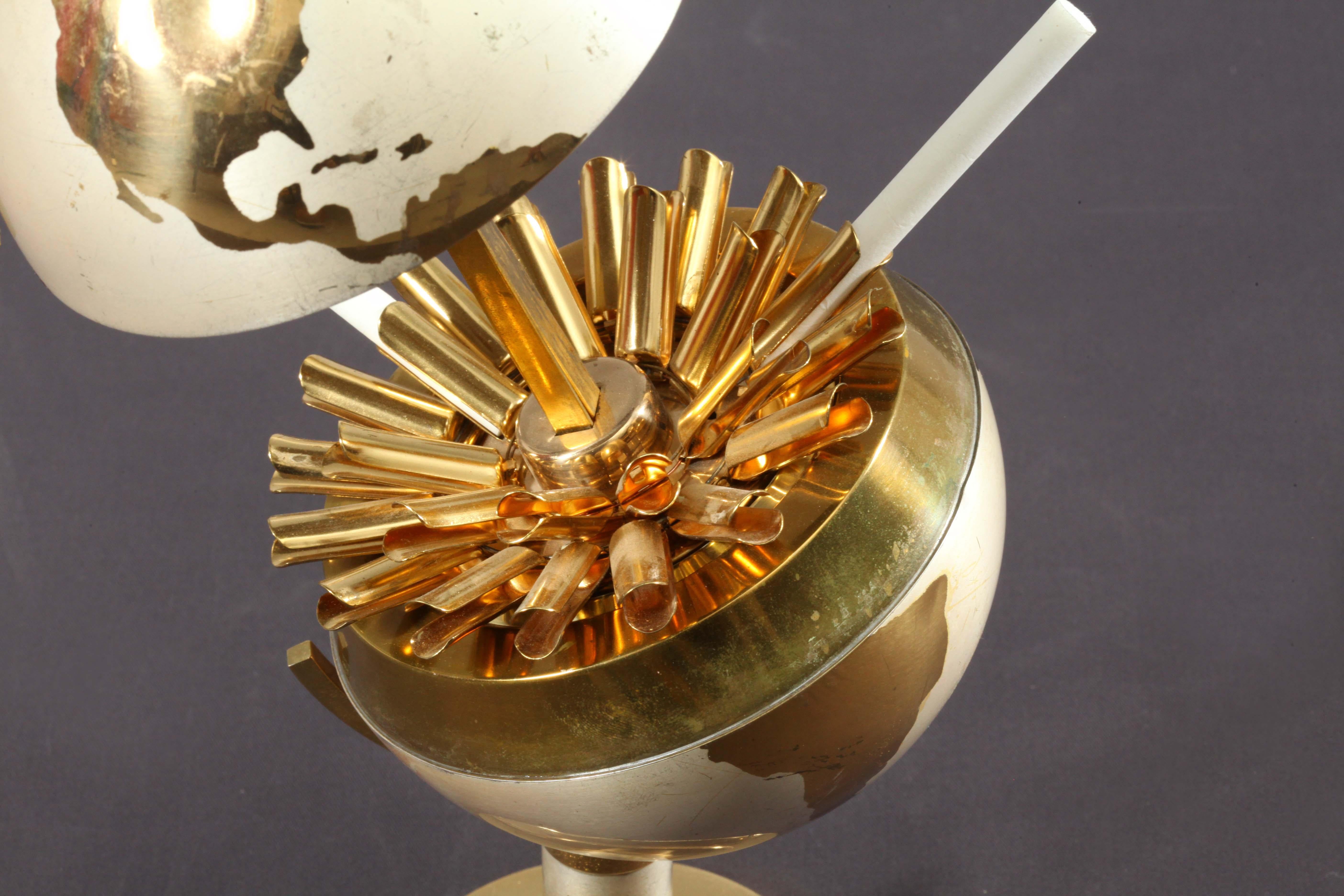 German 20th century vintage cigarette holder or dispenser designed in the shape of a globe composed of solid brass. Its mechanic lifts upwards from a pull-ring on the top splitting it in half at the equator to reveal 25 tubes pop out cigarettes.
An