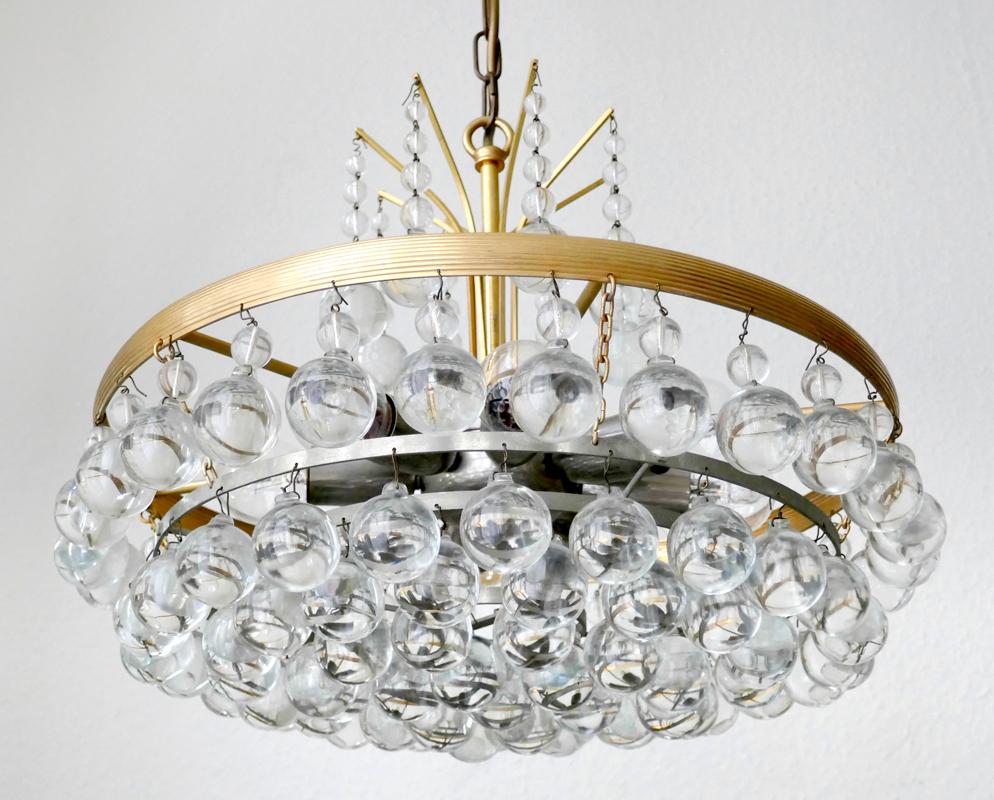 Wonderful massive crystal glass drops and gold/nickel-plated brass pendant chandelier.
Germany, 1960s.
Measures:
Diameter 17 in
Height (body) min.: 7.1 in. 
Lamp sockets: 8.

