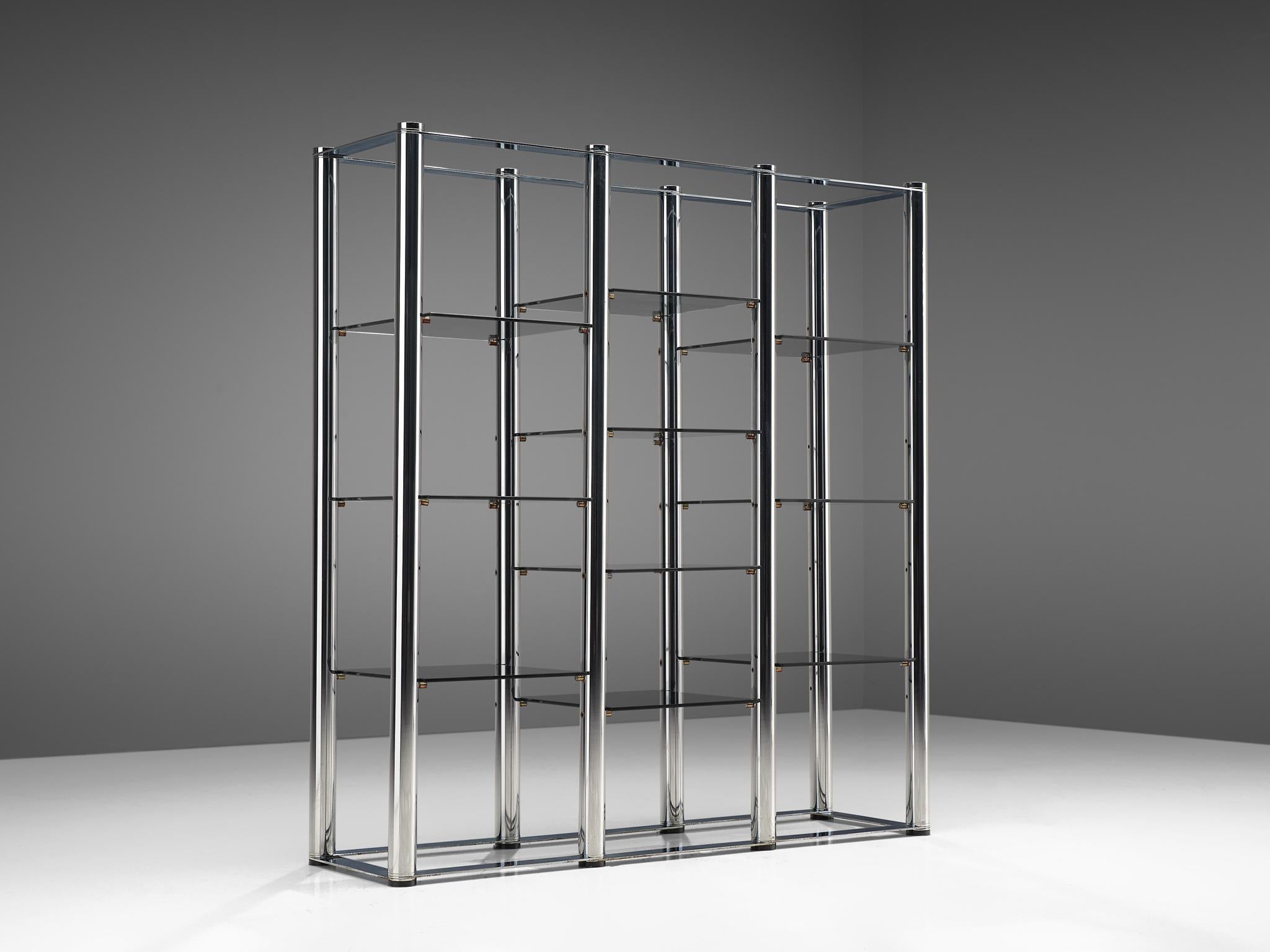 Étagère, chrome and glass, Germany, 1960s.

Germany shelving unit with a chrome tubular frame. The frame consists of thick tubes which is a striking combination with the thin smoked glass shelves. This creates an interesting visual effect, with