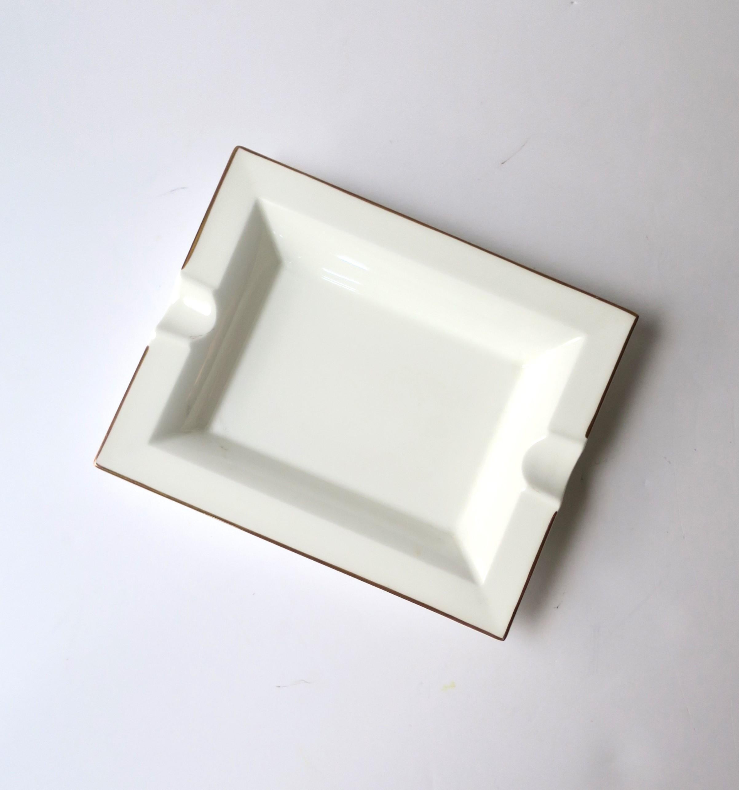 A German white porcelain tray vide-poche (catch-all) or ashtray with gold edge, circa late-20th century, Germany. A great standalone piece/tray to hold jewelry (as demonstrated) or other items on desk, vanity, nightstand, end table, etc. Or use for