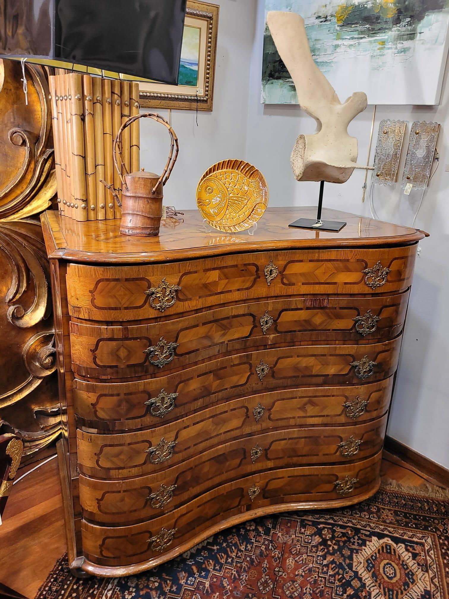 One of a kind serpentine chest of drawers with marquetry decorations in walnut wood and other precious woods from the Bavarian region of Germany.

Divided into 6 registers, each of them has an undulating shape, characteristic of the comfortable
