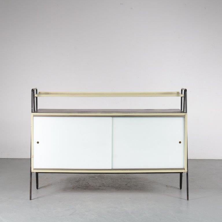An incredibly rare, original sideboard by Gerrit Rietveld Jr., manufactured in the Netherlands around 1950.

The cabinet has a beautiful, minimalist Dutch style. Made of high quality wood with elegant glass sliding doors and round perforations for