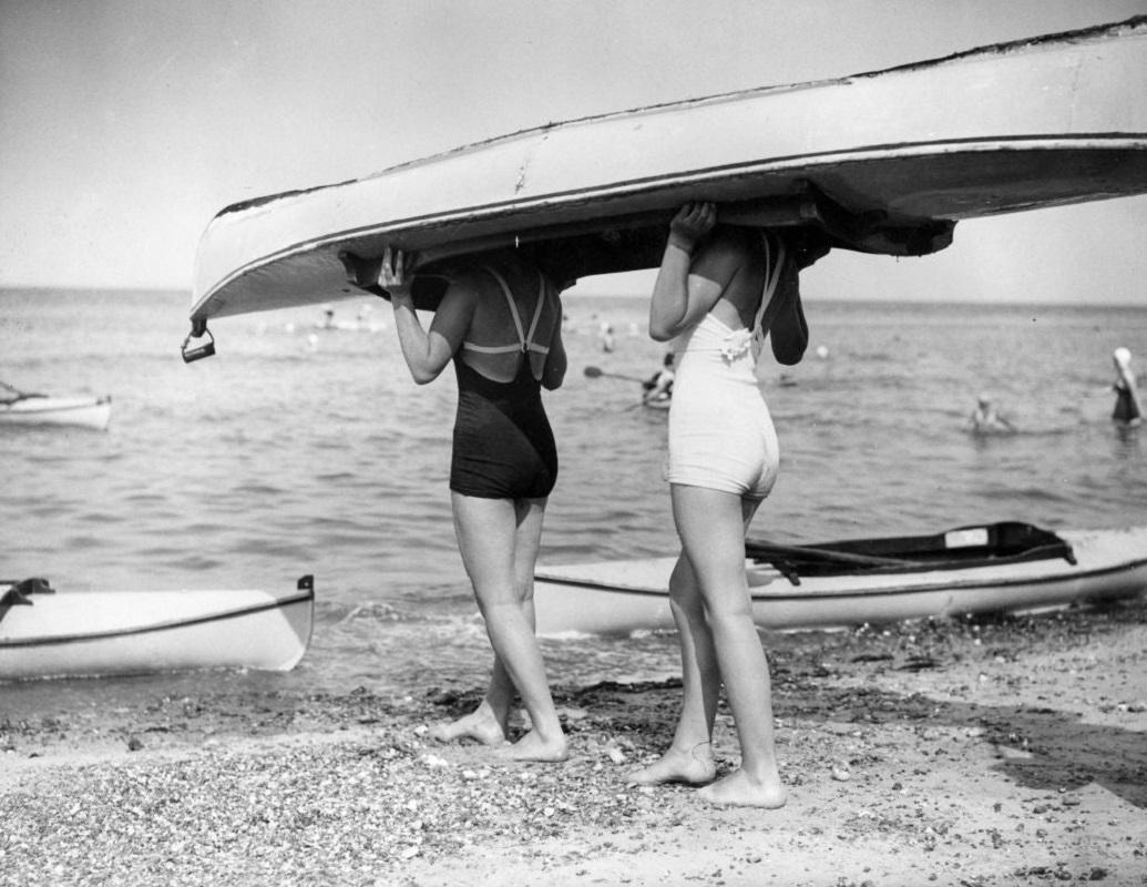 "Boat Bearers" by Gerry Cranham

30th July 1938: Two swimsuited girls are carrying their canoe on their heads.

Unframed
Paper Size: 20" x 24'' (inches)
Printed 2022 
Silver Gelatin Fibre Print