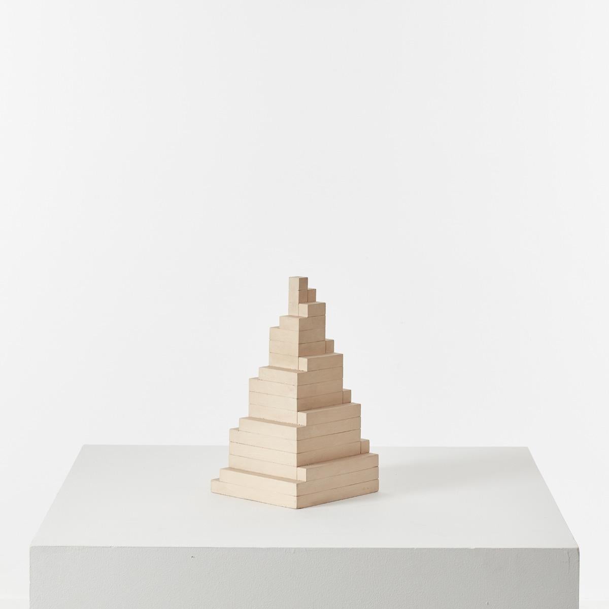 This lovely architectural sculpture by Dutch artist Gert Jan Verhoog has been precisely sculpted from painted wood. Its body is formed through the stacking of rectangular pieces scaling down in volume from the base to the top, reaching a point of