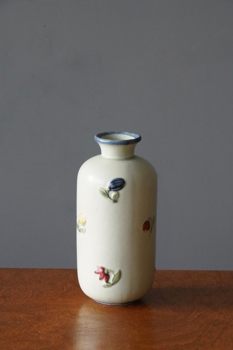 A vase, designed by Getrud Lönegren. Produced by Rörstrand. Stamped. Features relief decor illustrating floral motifs, hand-painted. 

Other designers of the period include WIlhelm Kåge, Stig Lindberg, Axel Salto, Arne Bang, and Gunnar Nylund.