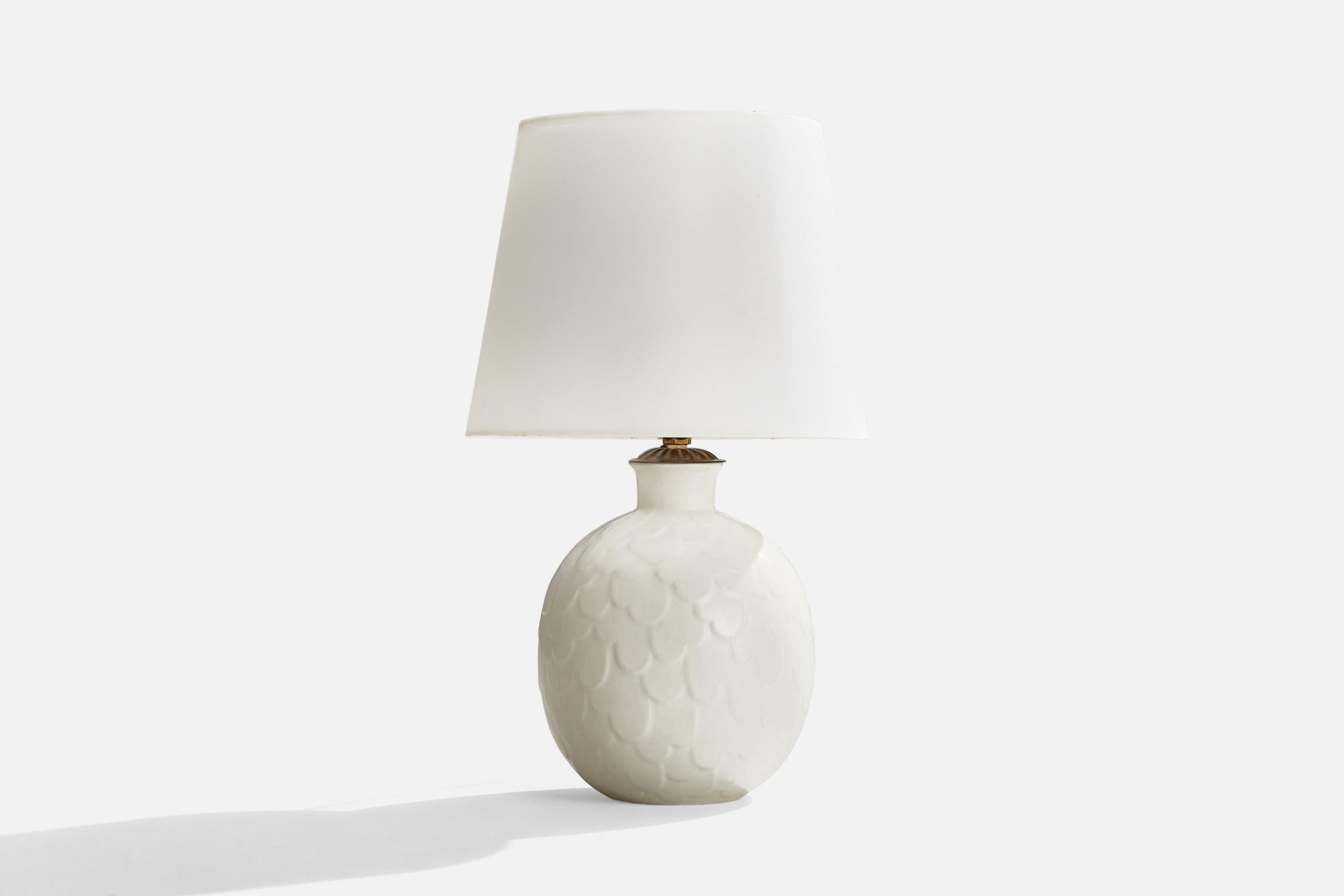 A white glazed stoneware and brass table lamp designed by Gertrud Lönegren and produced by Rörstrand, Sweden, c. 1940s.

Dimensions of Lamp (inches): 11.5” H x 7” Diameter
Dimensions of Shade (inches): 7.5”  Top Diameter x 10” Bottom Diameter x 8”