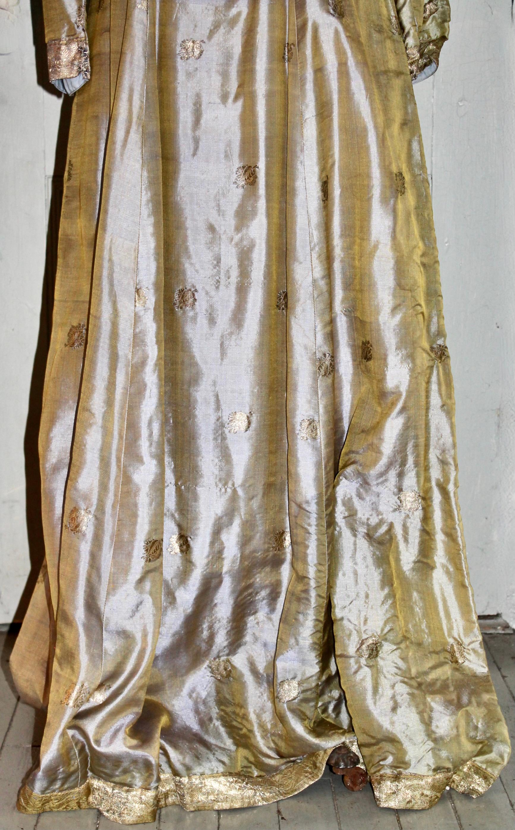 A rare 1960's formal dress by important American designer Gertrude Arzt of Huntington Texas.  Indian inspired overall pattern in gold thread on a satin/silk morphing color from yellow to violet. Lined.