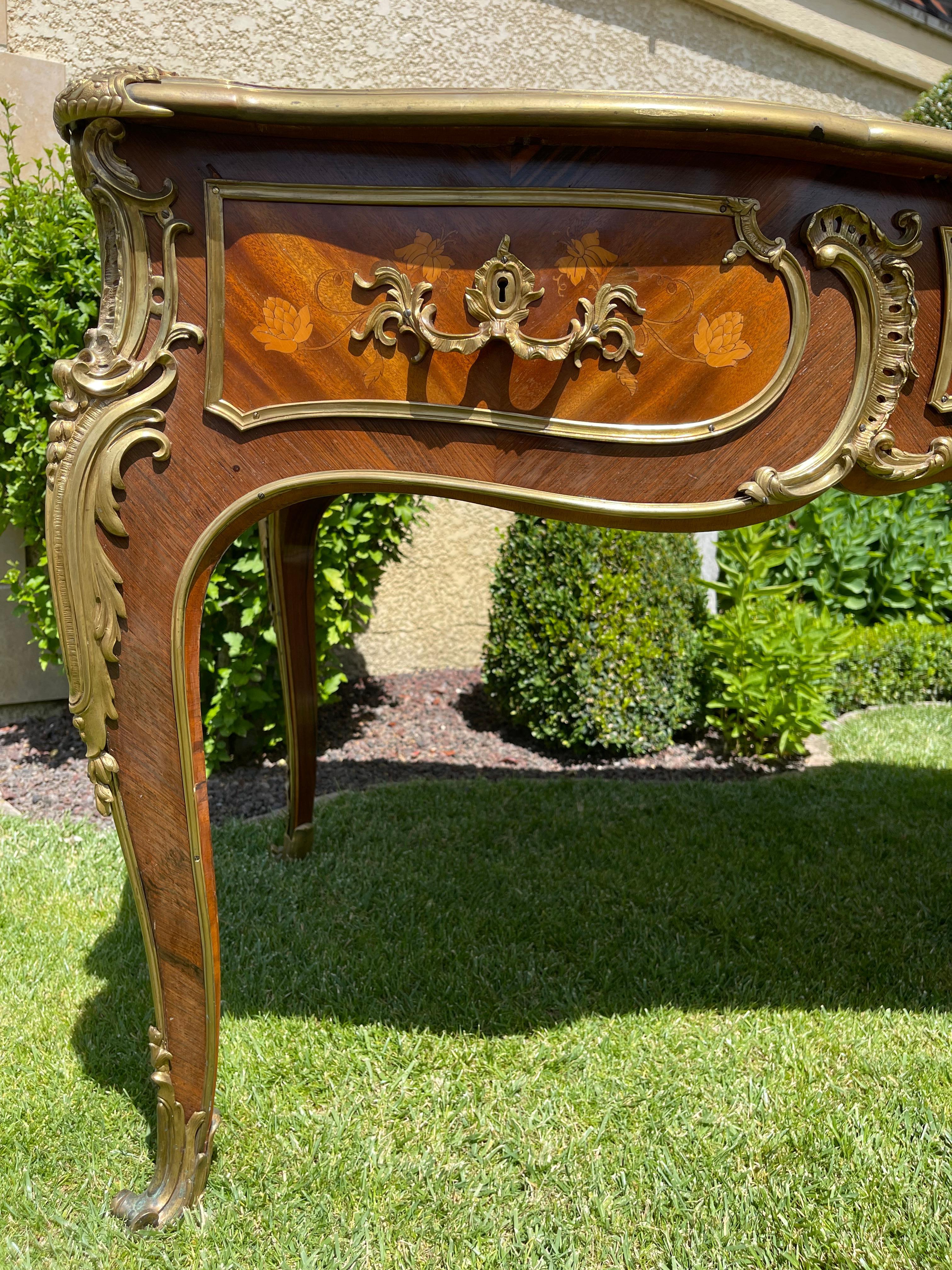Beautiful flat Louis XV style desk. It is inlaid with chiseled golden bronzes. It is double sided so can be placed in the center of a room. On one side, it has 3 drawers and the leather on the tray is to be changed.
Signed inside a drawer 