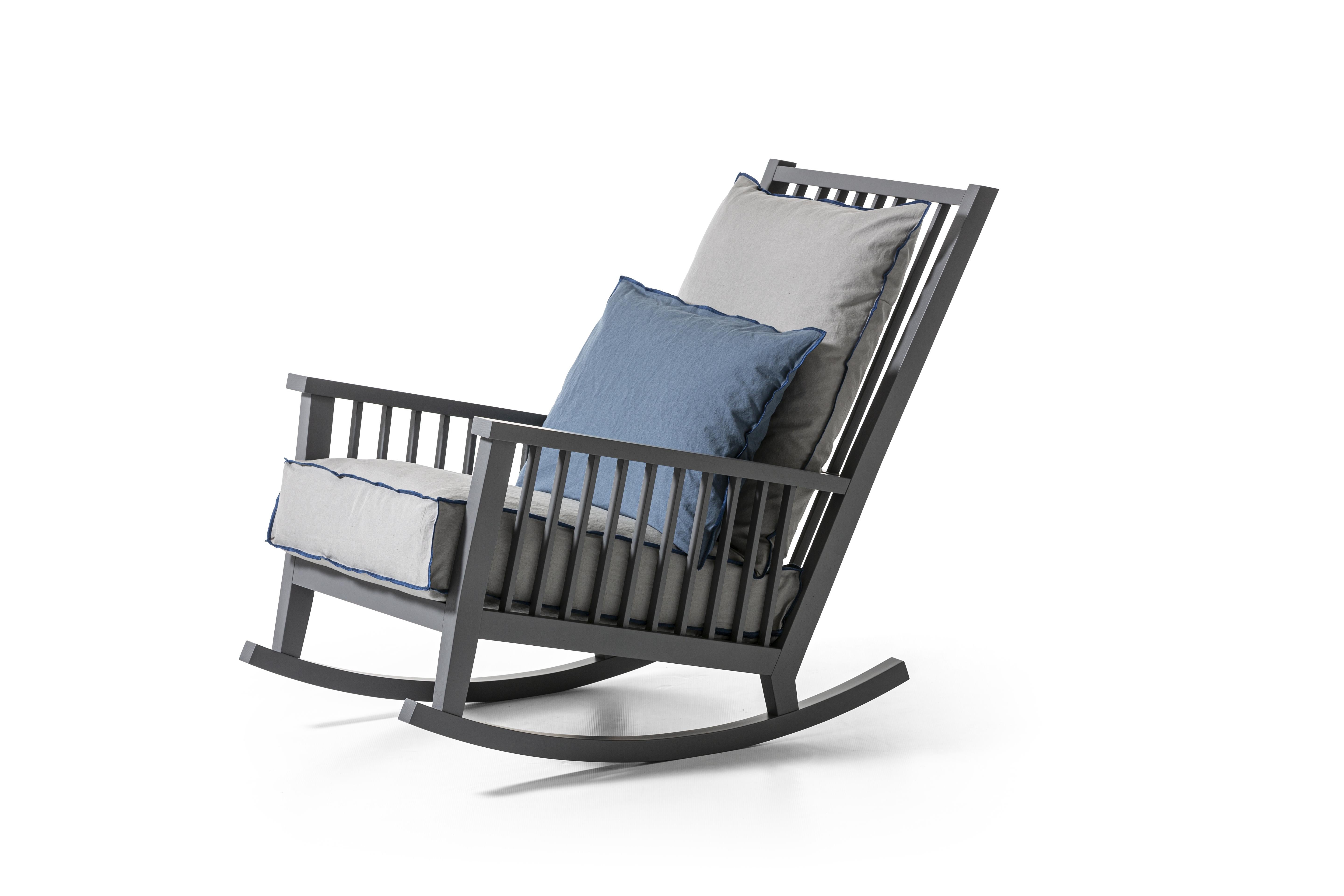 Rocking chair in wood, Gray 09 is characterised by a high backrest with visible slats on which a soft loose cushion rests. The structure, with a large and welcoming seat, is made of natural painted Canaletto walnut, bleached oak or white, grey,