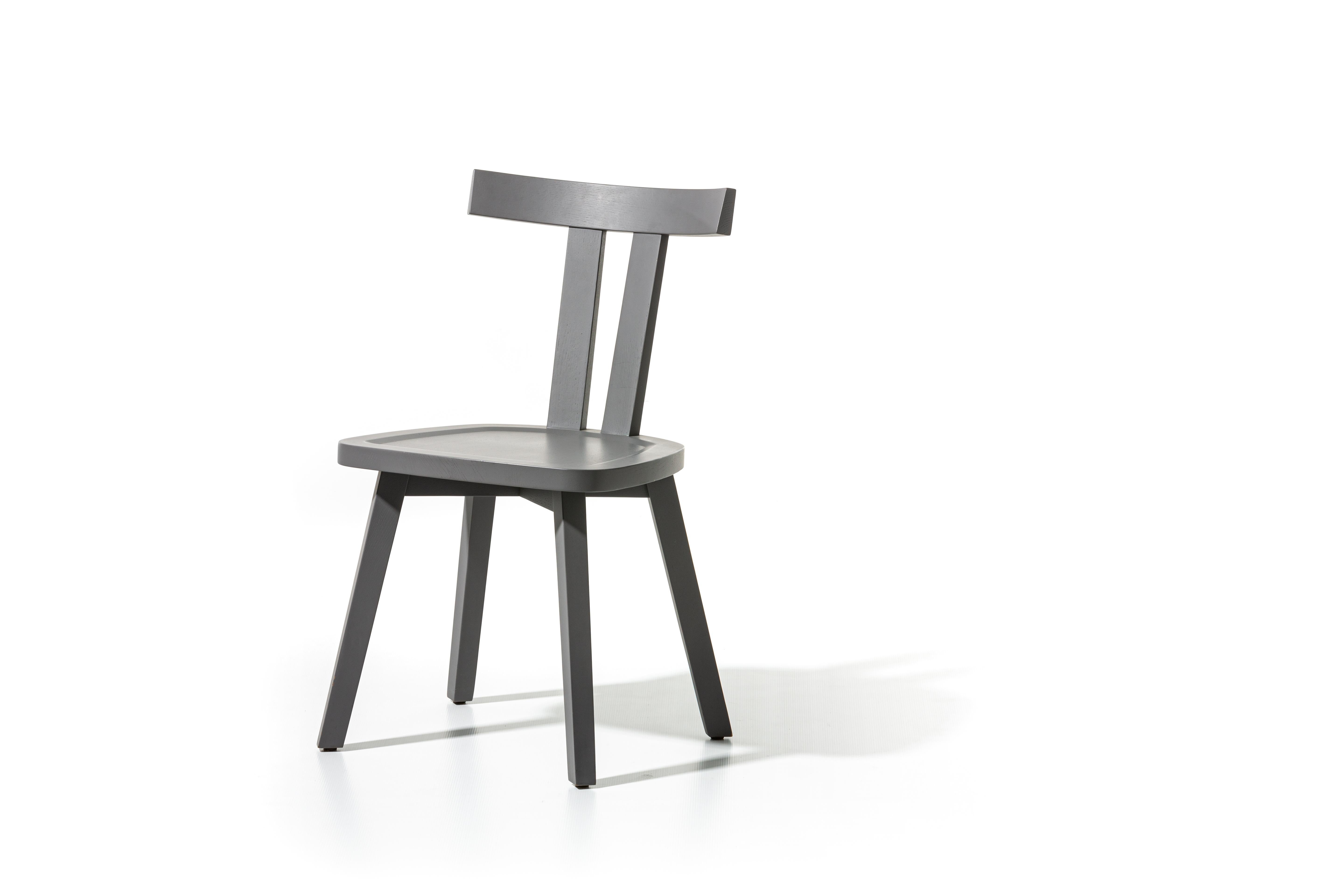 Der Stuhl Gray 23 zeichnet sich durch eine besondere und minimale Rückenlehne aus: drei große Holzlatten, zwei vertikale und eine obere horizontale, die den Sitz umschließen. Das Gestell besteht aus naturlackiertem Canaletto-Nussbaum, gebleichter