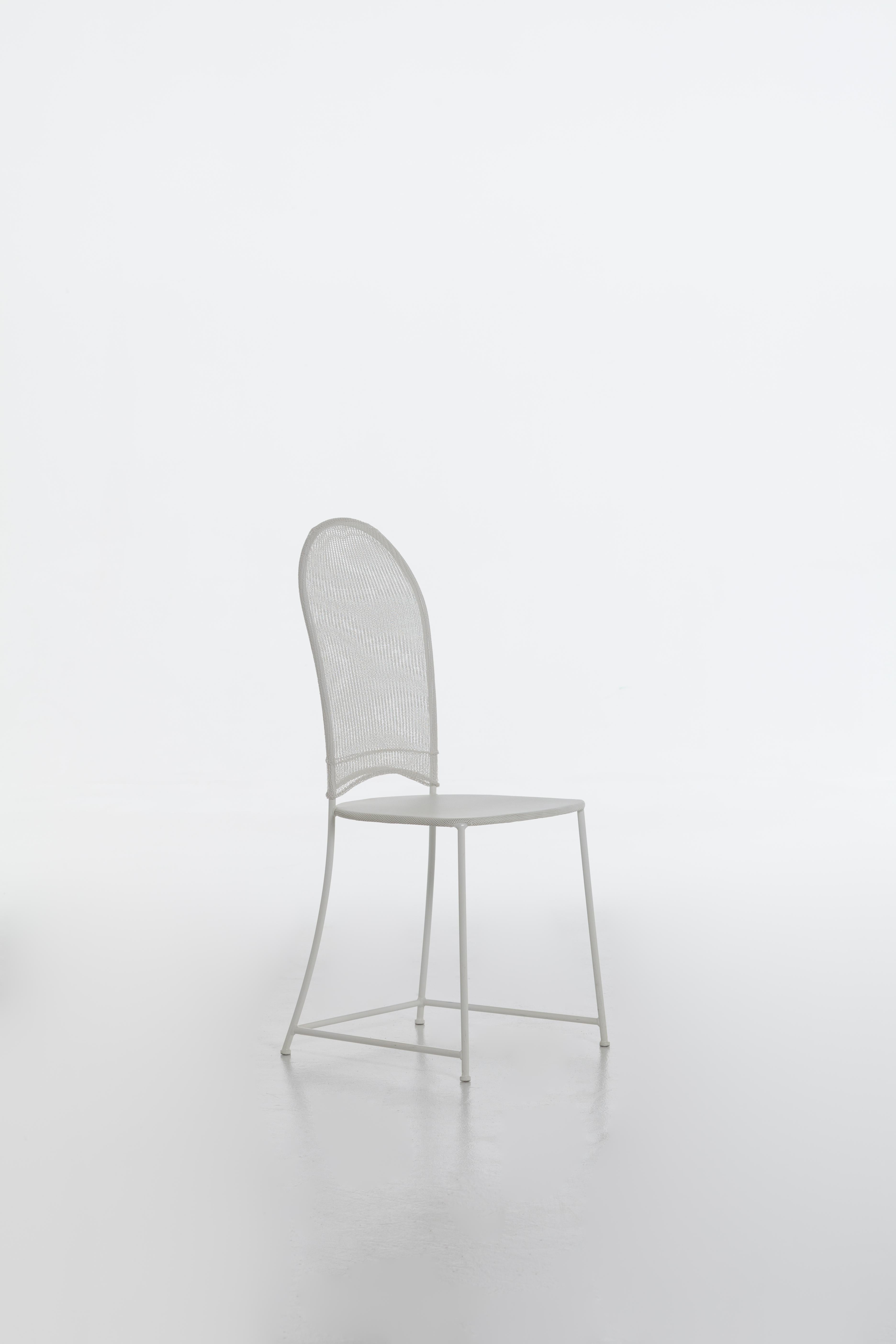 Essential chair, Inout 873 is characterised by a minimal structure made in white or grey painted steel. The seat is made of micro-perforated steel sheet metal, while the rounded backrest is upholstered in removable mesh in white or grey heat-sealed