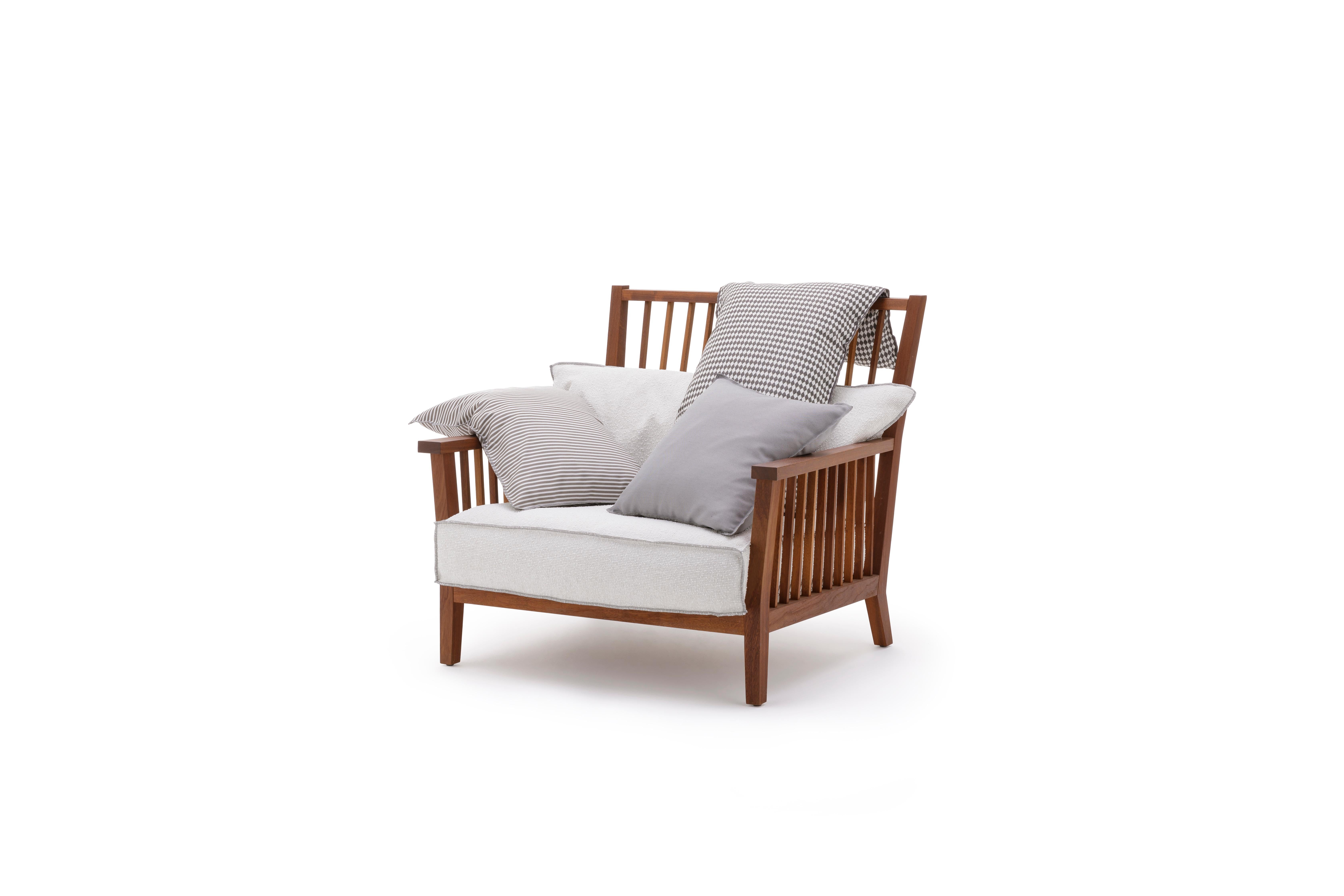 Sillón envolvente y cómodo, Inout 701 tiene una estructura de listones: está hecho de iroko aceitado, una madera especialmente duradera porque es naturalmente resistente al agua y la humedad. El contraste entre la solidez de los listones anchos y la