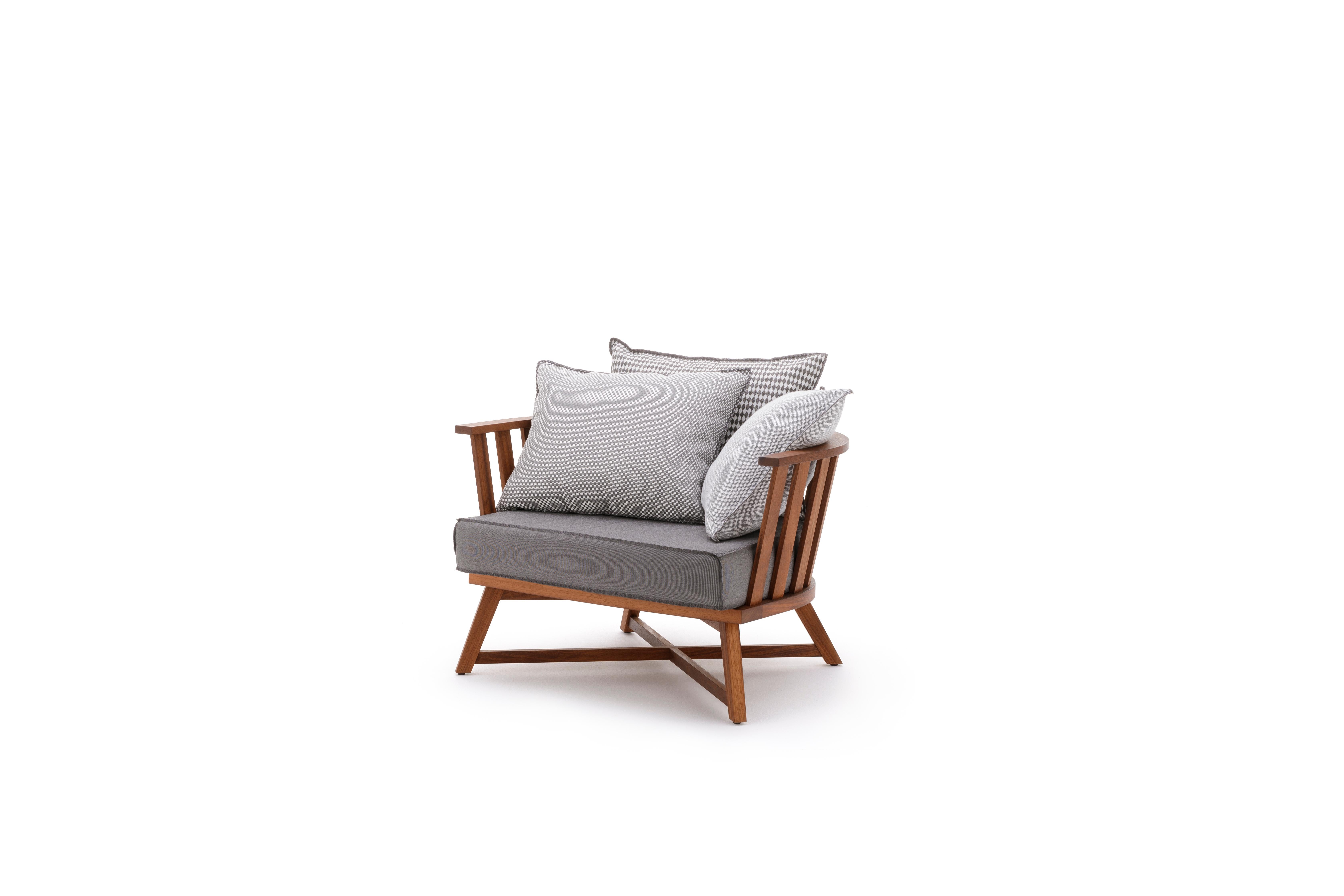 Enveloping and comfortable armchair, Inout 707 has a semi-circular slatted structure, with legs that intersect to form a cross: it is made of oiled Iroko, particularly durable wood because it is naturally resistant to water and moisture. The