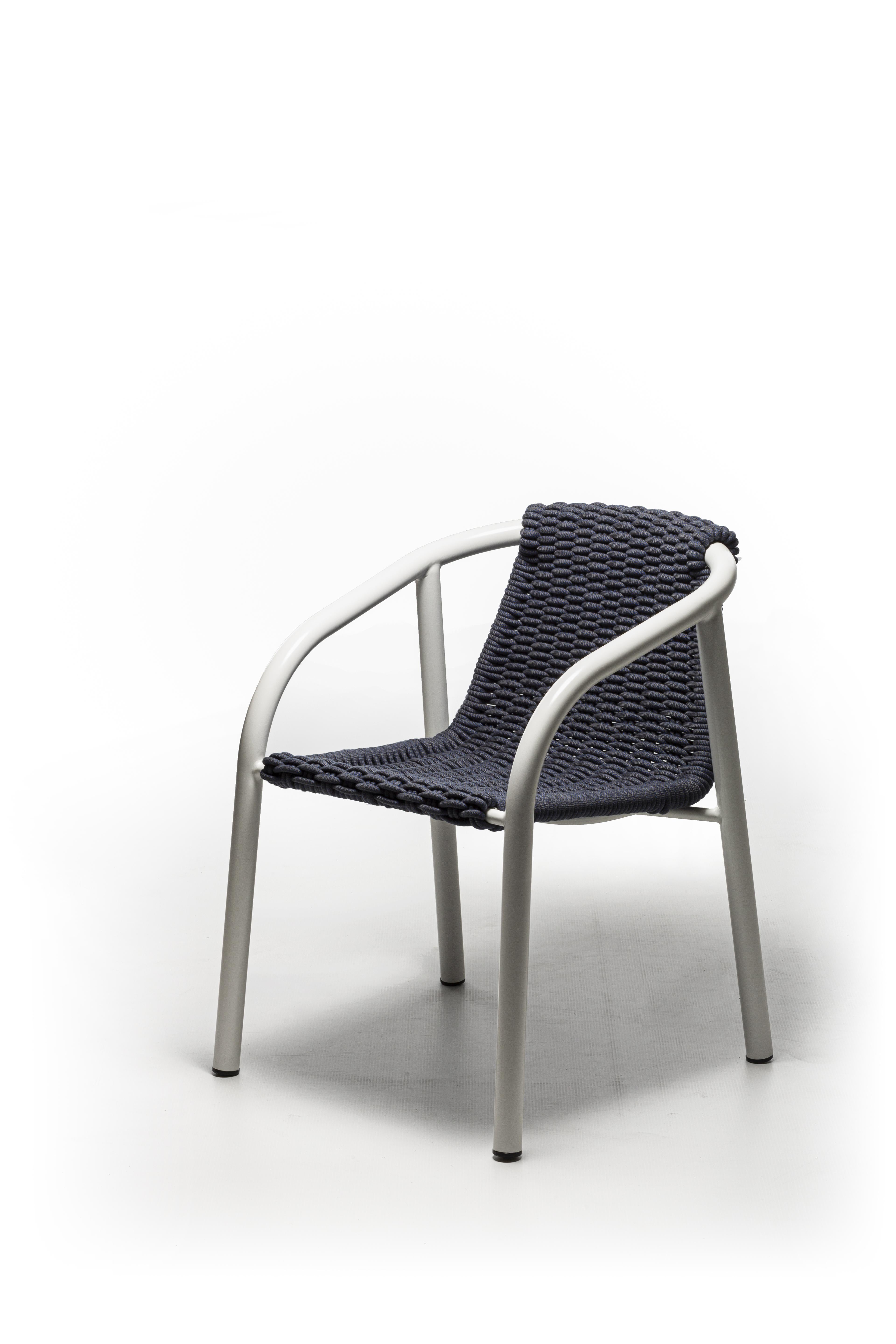 The Ken 23 chair, characterised by a minimal and informal style, is formed by a structure in matt white or grey painted tubular aluminium, a unique metal for its technical qualities, combined with a handmade weaving in grey or blue polyester
