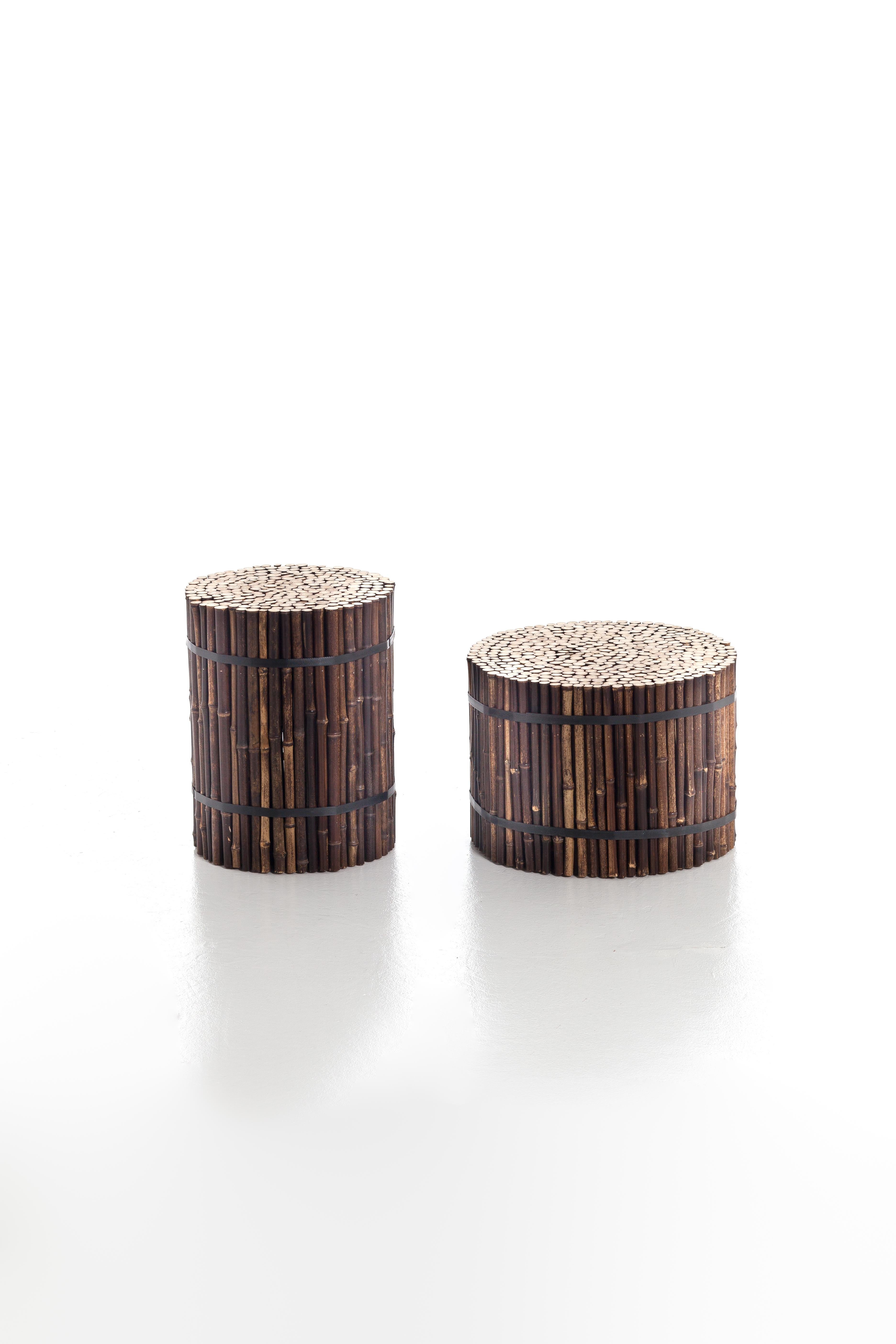 Exotik und minimaler Charme vereinen sich in der Familie der zylindrischen Black 19/21 Poufs aus schwarzem Bambus. Sie sind in zwei Größen erhältlich und erinnern an die Idee eines Bündels von Bambusrohren. Ottomane aus schwarzem