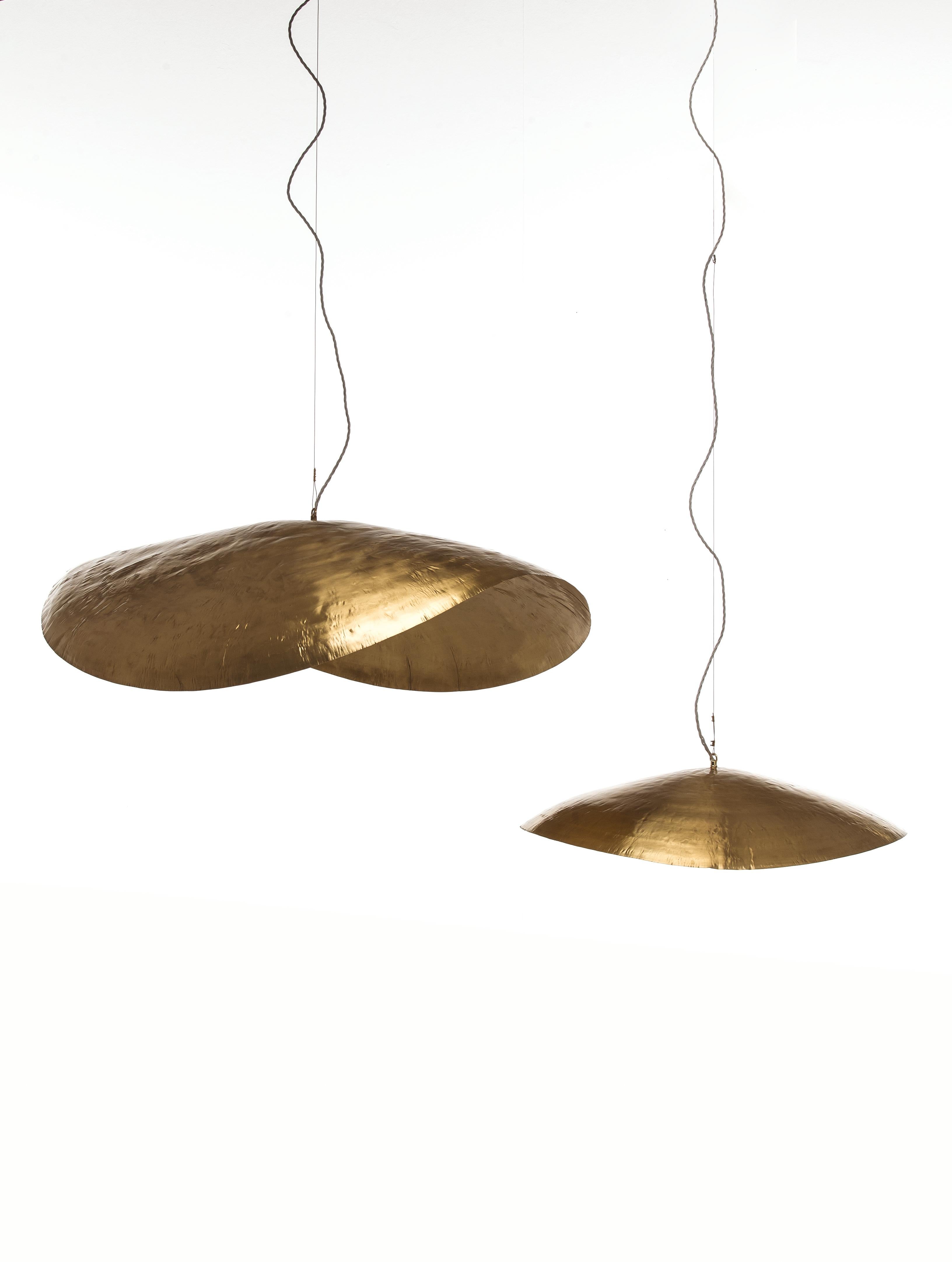 With a strong decorative impact, the BRASS lamp family exploits the ductility of brass and its ability to embellish interiors with warm and golden light reflections. Suspension lamps have a delicate shape of great visual appeal: a light brass disc