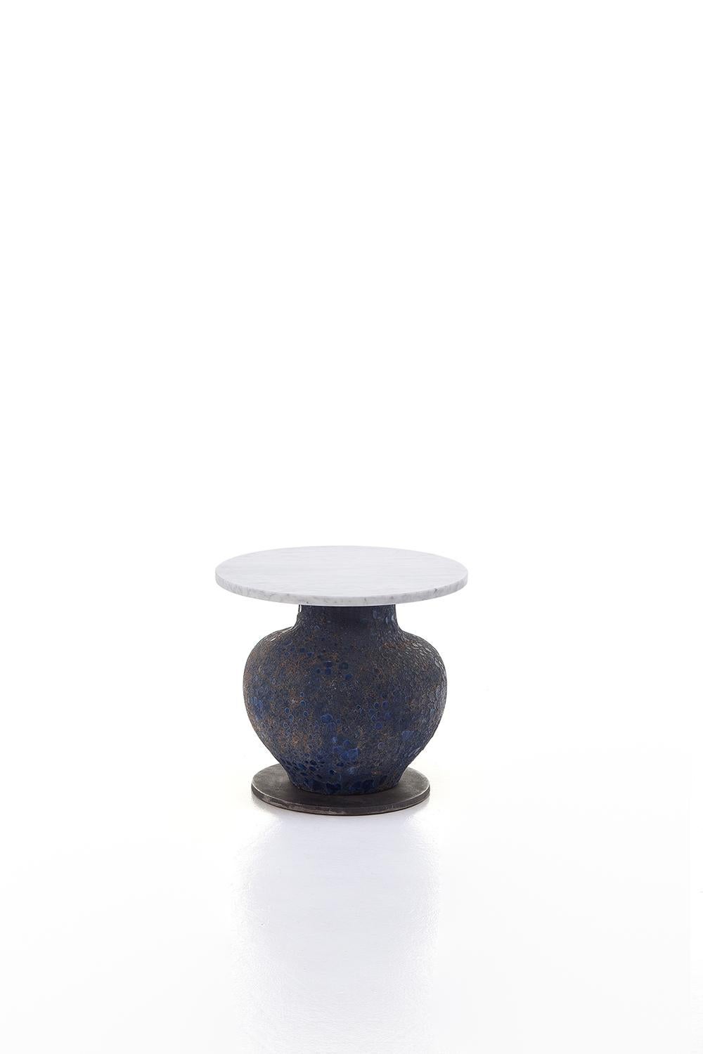 A bold combination of materials distinguishes the Moon 39/40/42 family of tables: available in different sizes, they have a blue ceramic base in the shape of an amphora, more or less elongated according to the height of the product, characterised by